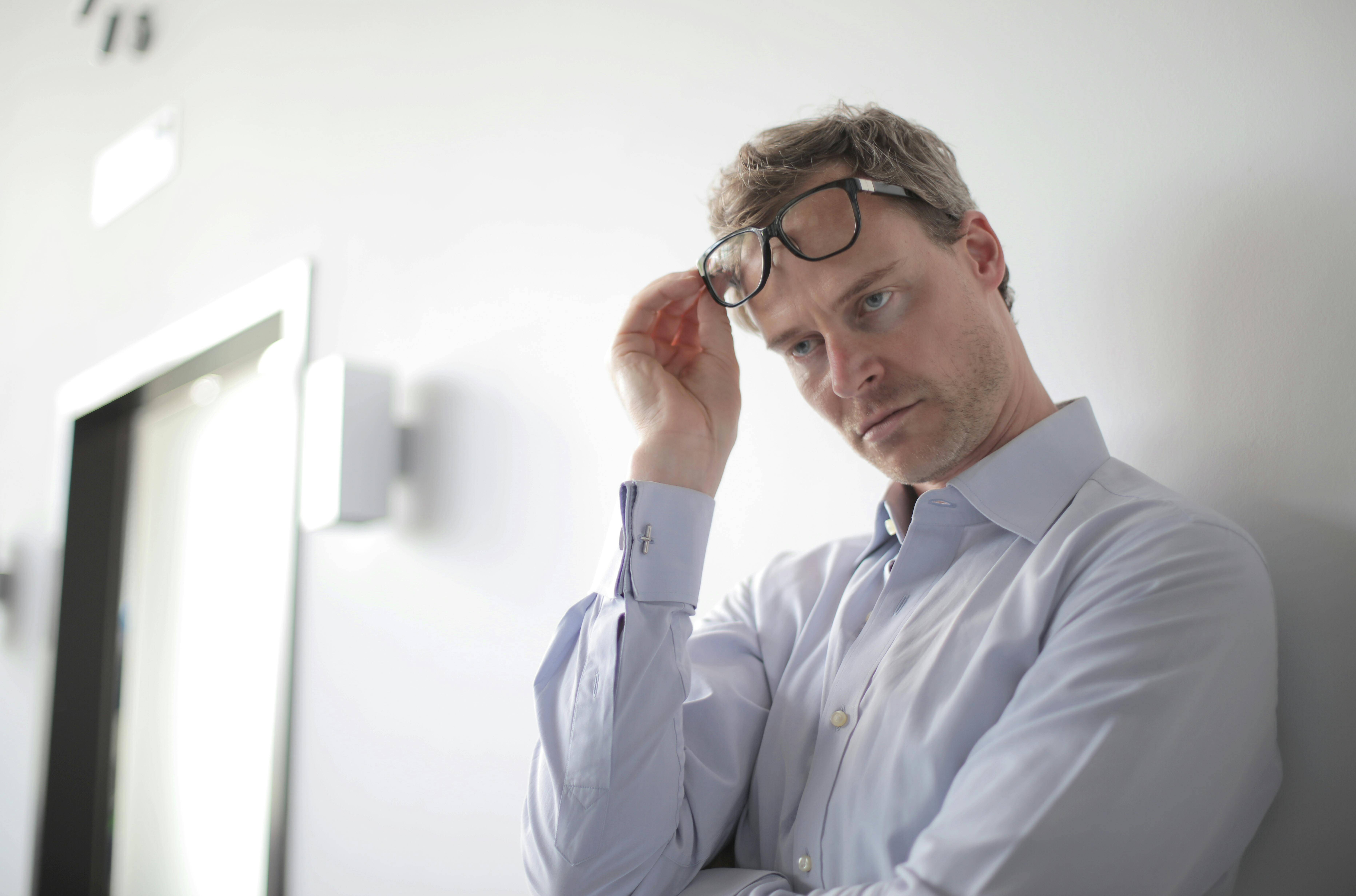 Un hombre de pie con las gafas en la cabeza | Fuente: Pexels