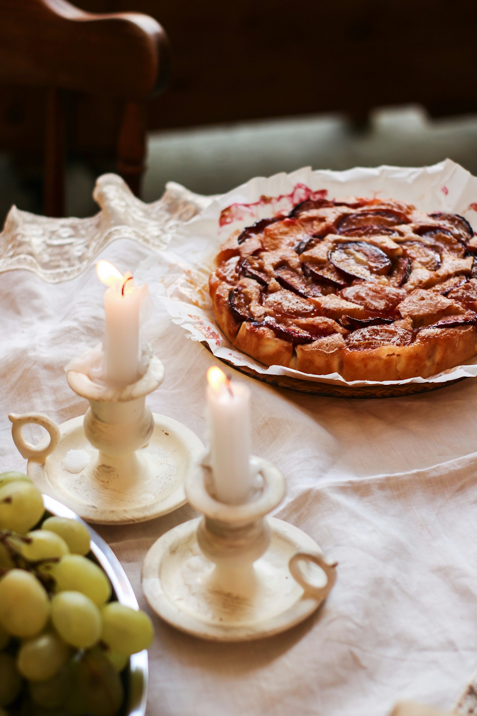 Un cuenco de uvas, velas y un plato de tarta sobre la mesa | Fuente: Unsplash