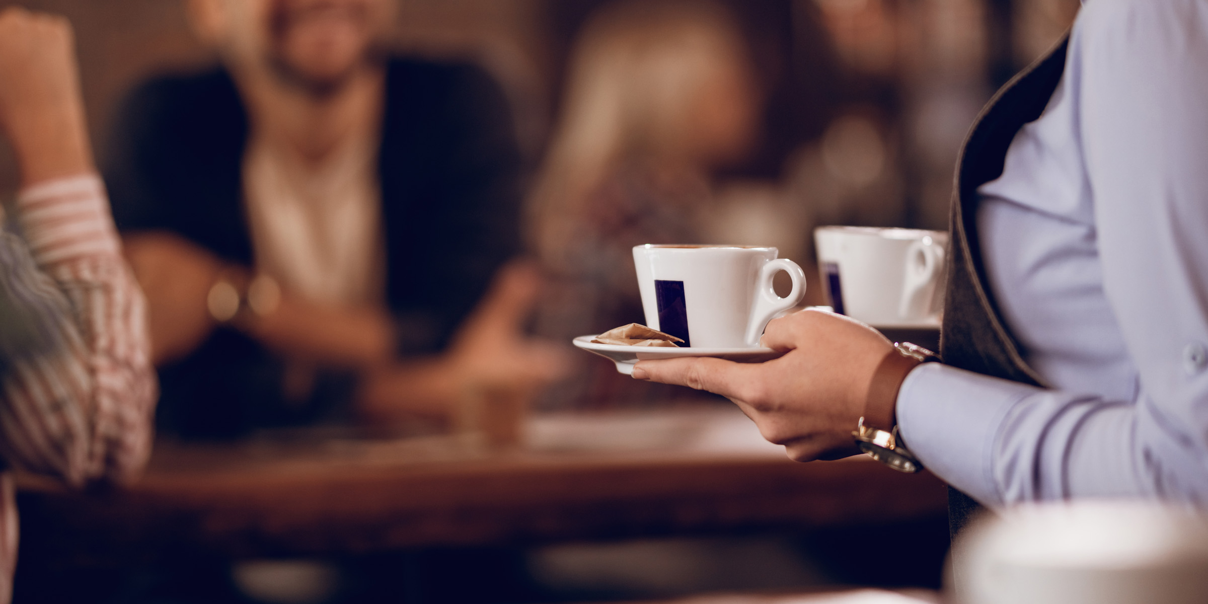 Una camarera sosteniendo tazas de café | Fuente: Freepik