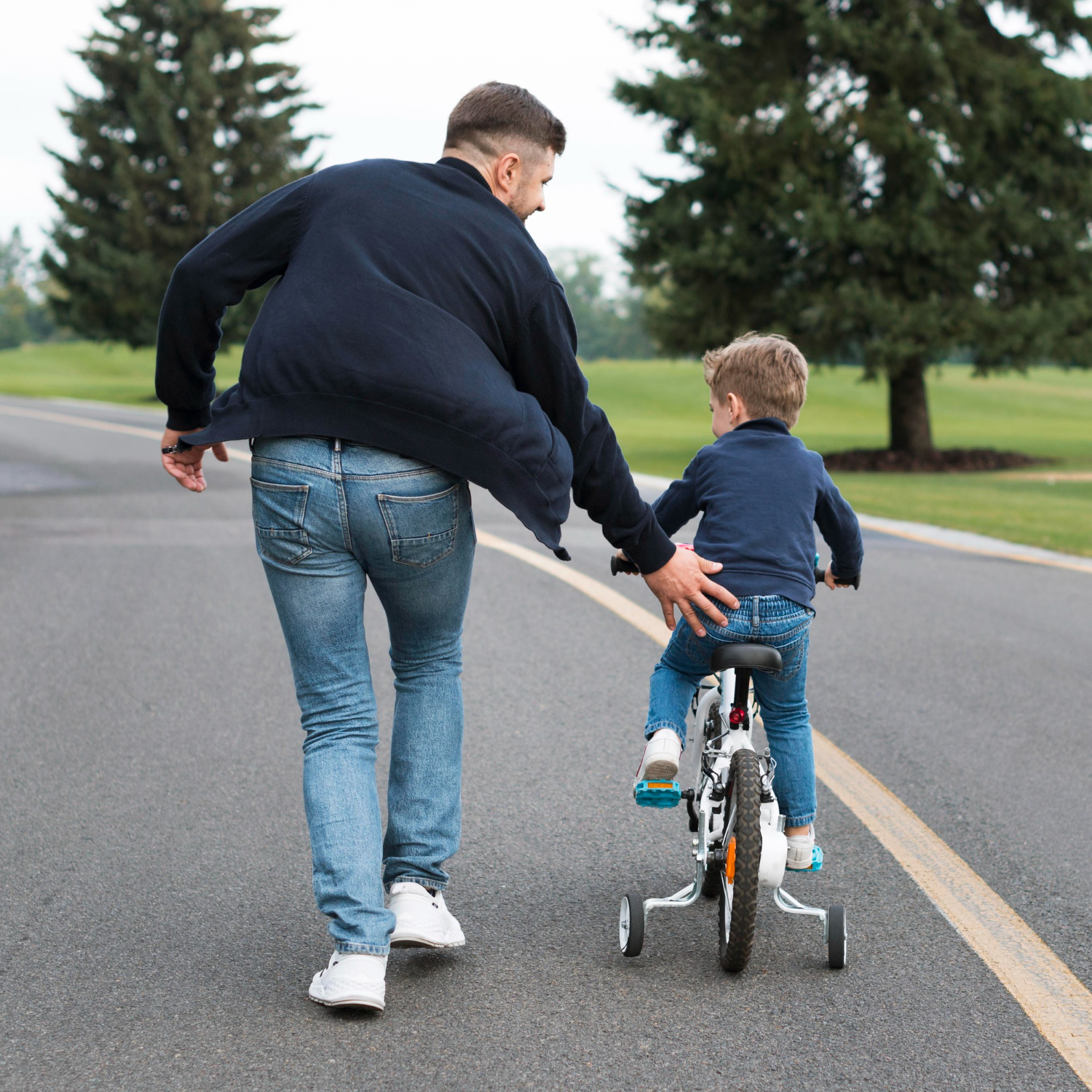 Un papá enseñando a su hijo a andar en bicicleta | Fuente: Freepik