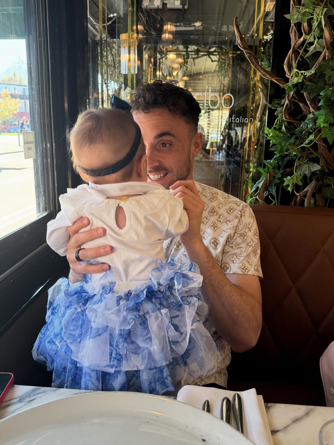 Diogo Jota sosteniendo a su pequeña hija en brazos mientras están en un restaurante | Fuente: Instagram/rutecfcardoso14