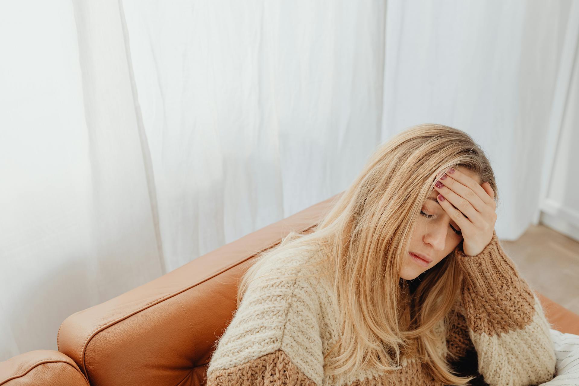 Una mujer cansada sentada en un sofá | Fuente: Pexels
