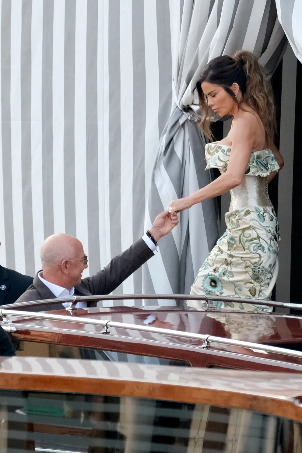 Jeff Bezos ayuda a su prometida Lauren Sánchez, con un vestido de alta costura de Schiaparelli, a subir a un taxi acuático en Venecia el 26 de junio de 2025. | Fuente: Getty Images