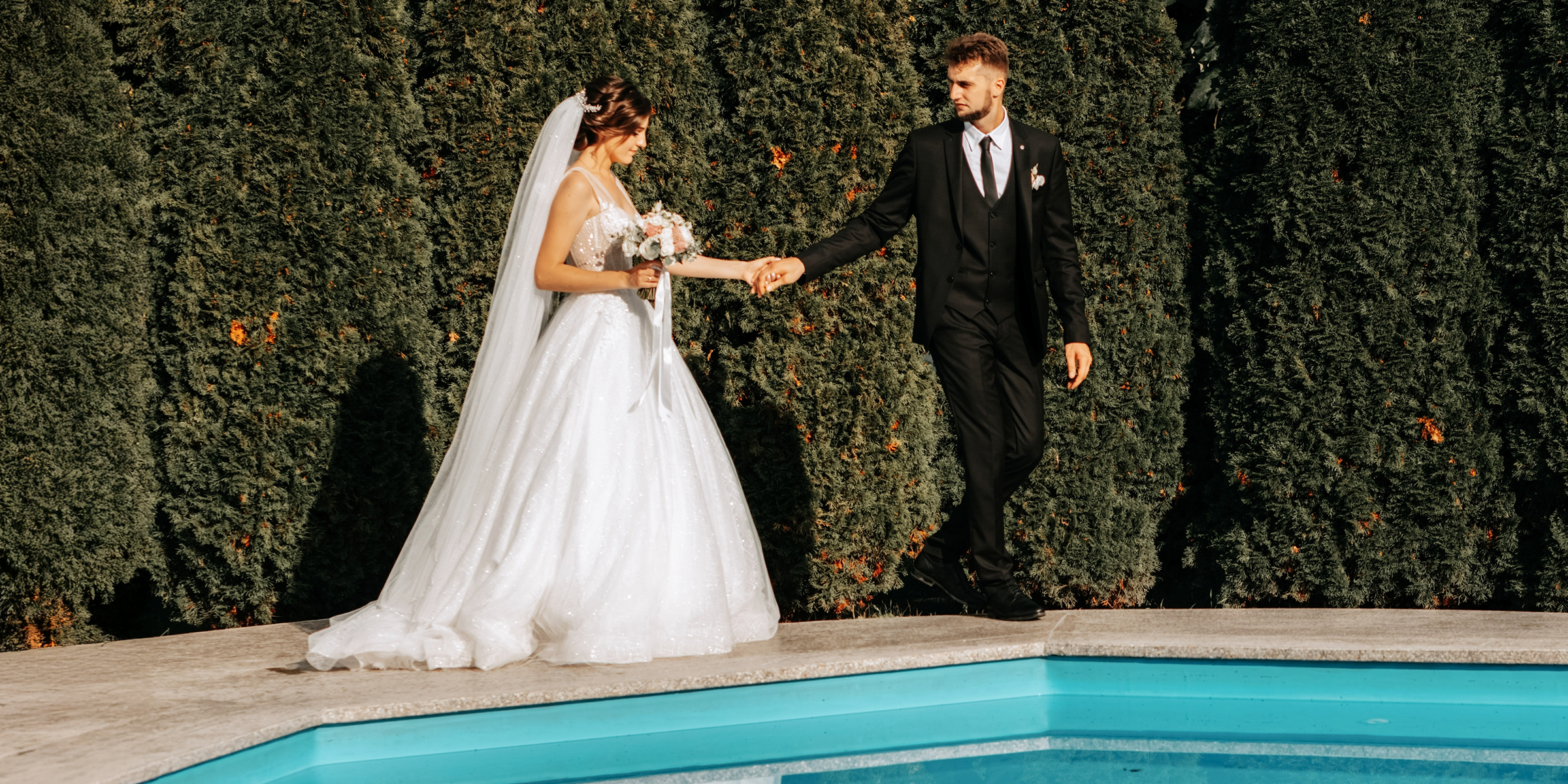 Una pareja de novios junto a una piscina | Fuente: Shutterstock