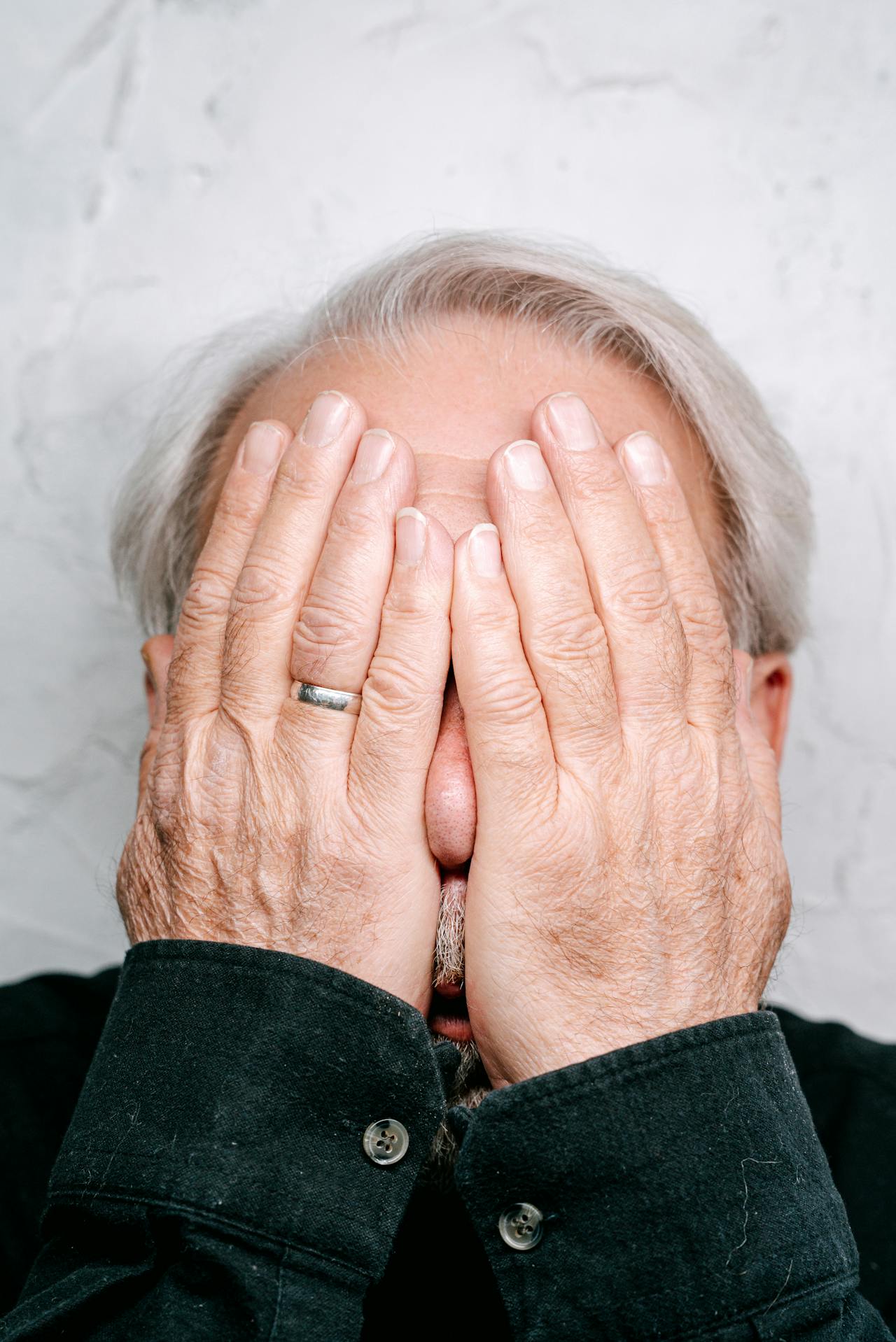 Un anciano angustiado cubriéndose la cara | Fuente: Pexels
