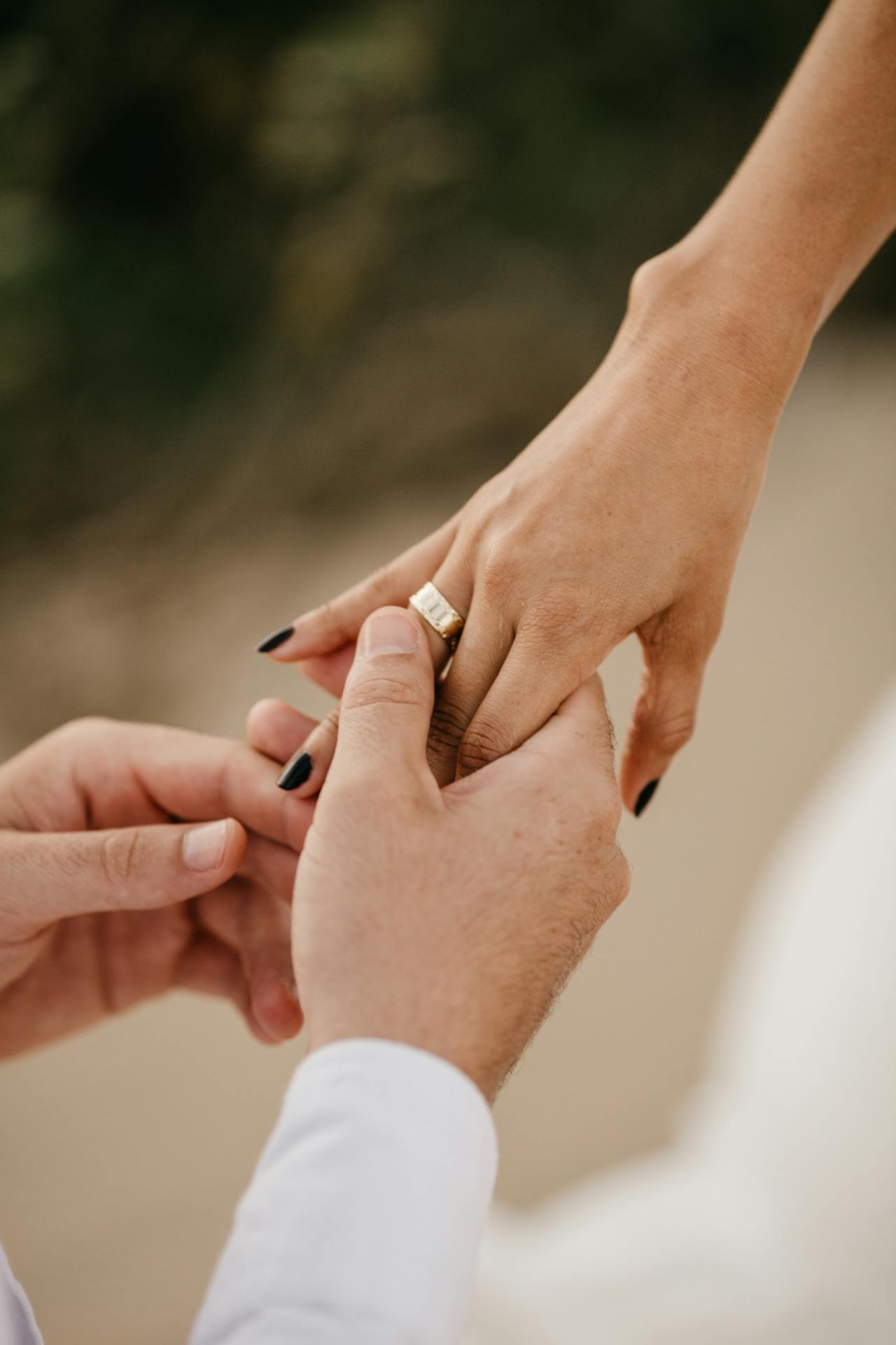 Un hombre deslizando un anillo en el dedo de una mujer | Fuente: Pexels