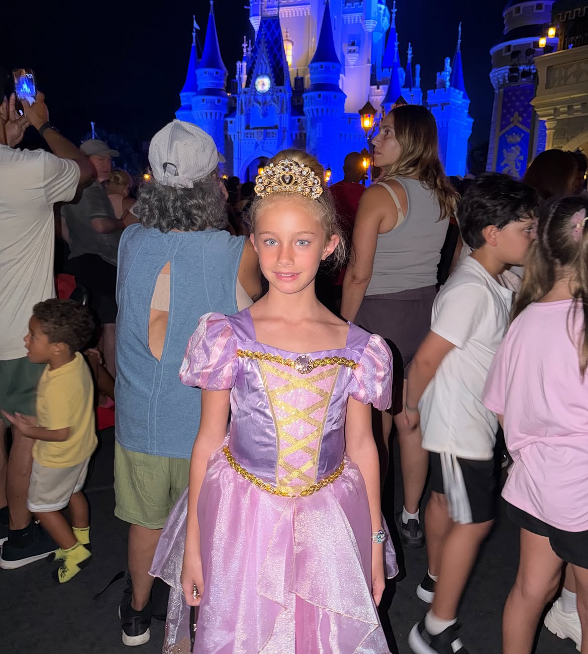 Matilda Salazar posando con su vestido rosa de princesa en un camino de Magic Kingdom, rodeada de gente | Fuente: Instagram/lovingmatilda