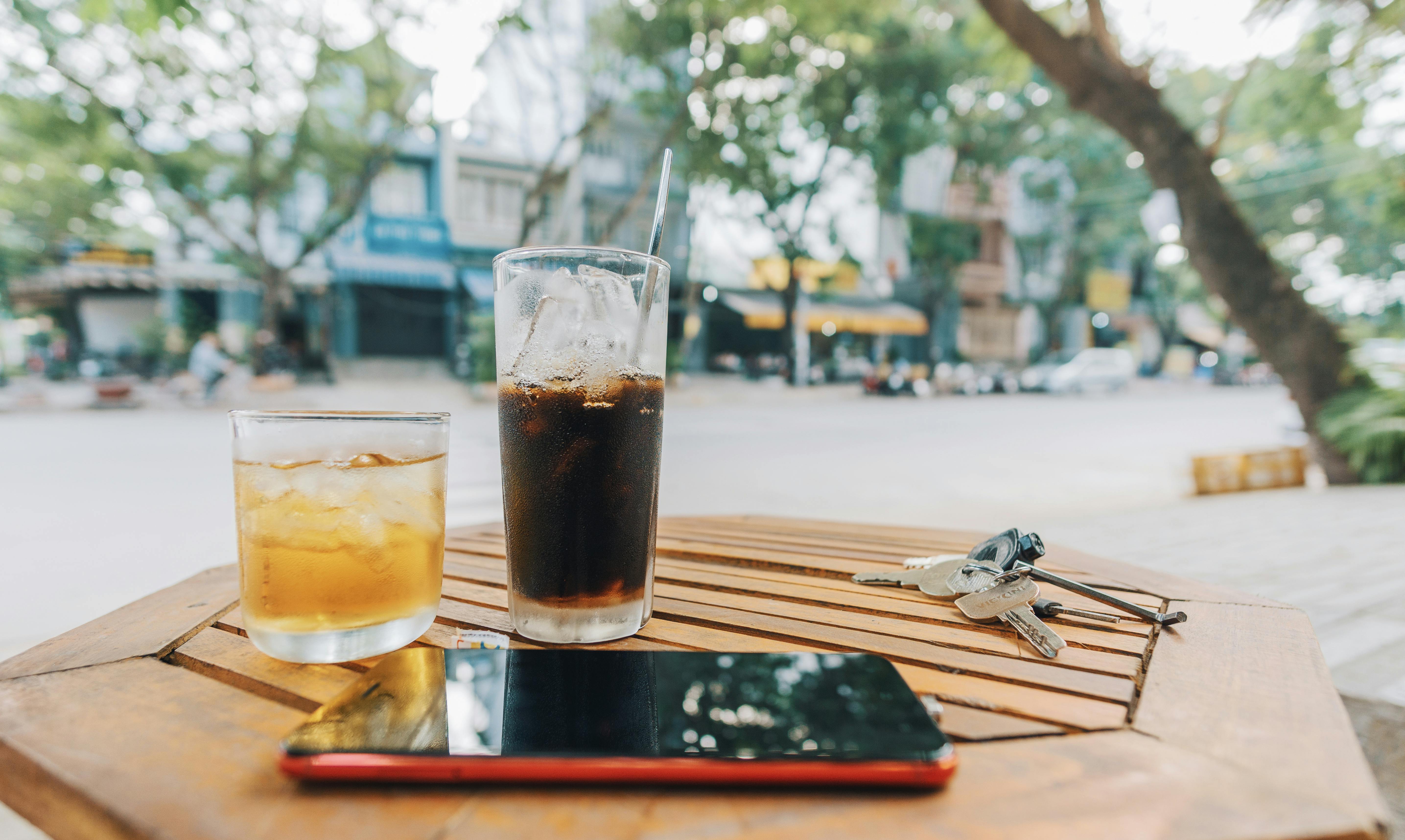 Bebidas, un teléfono y unas llaves sobre una mesa | Fuente: Pexels