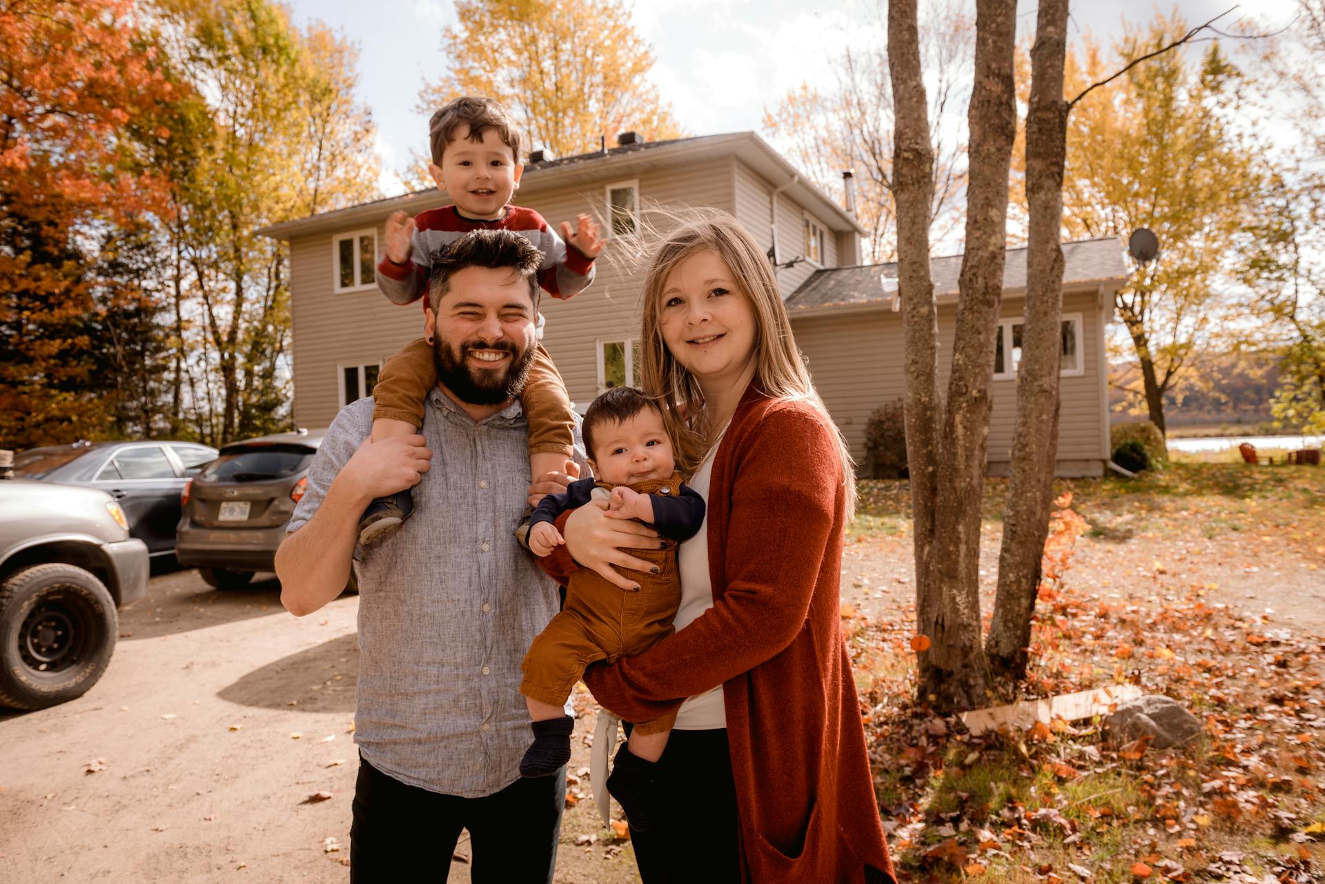 Una familia feliz delante de una casa | Fuente: Pexels