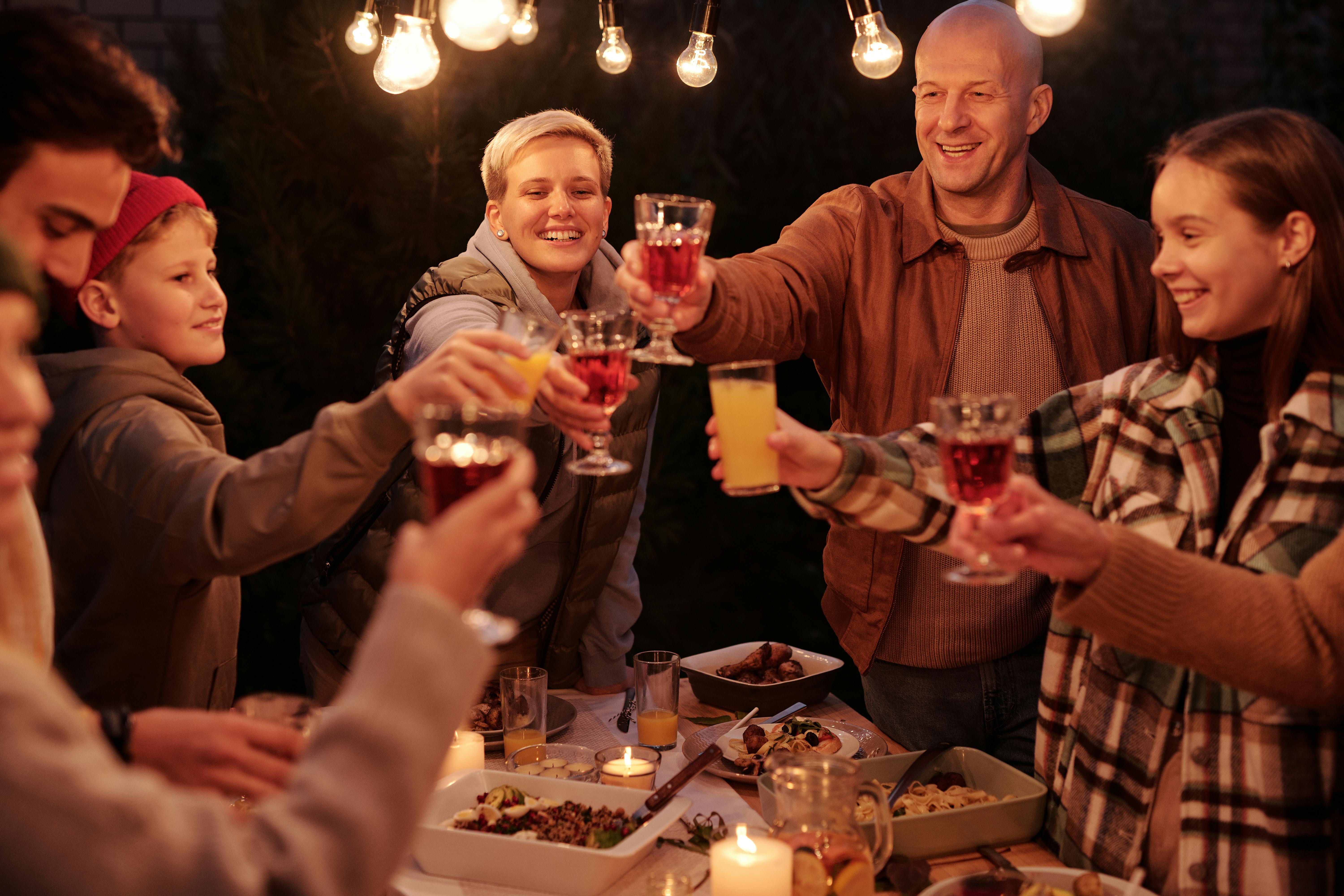 Una familia brindando bajo las luces | Fuente: Pexels