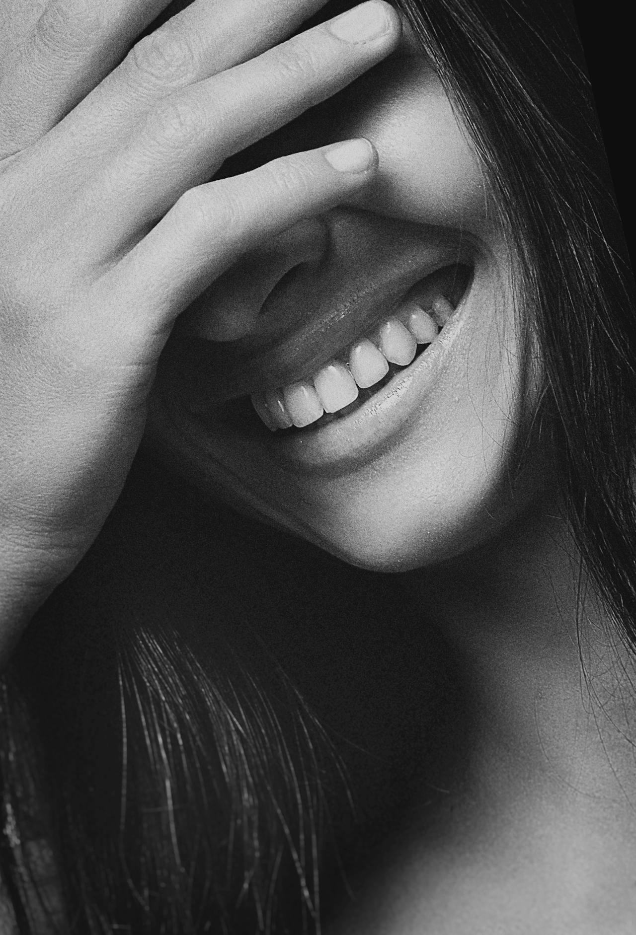 Toma en escala de grises de una joven riendo | Fuente: Pexels