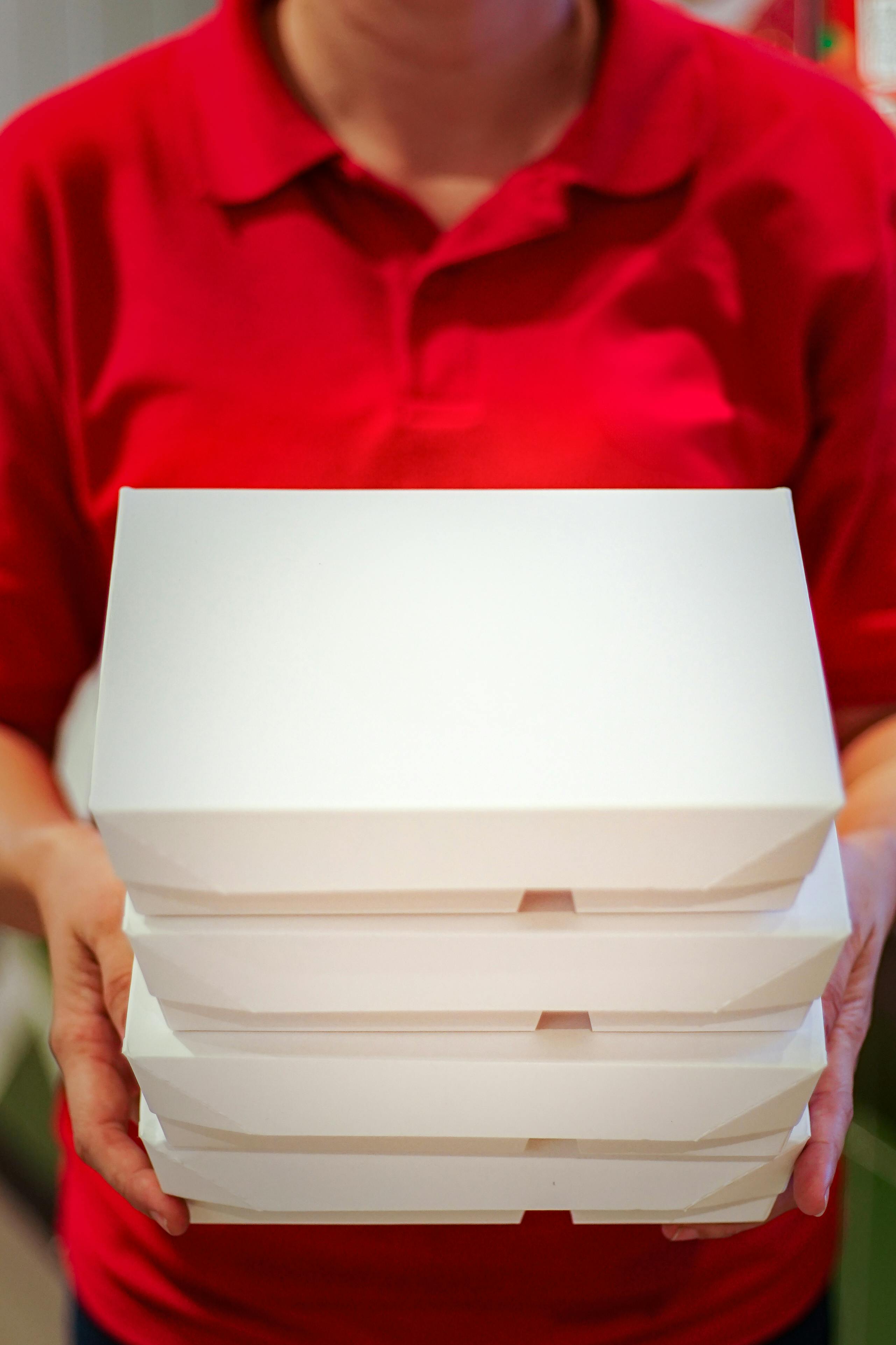 Alguien sujetando contenedores de comida para llevar | Fuente: Pexels