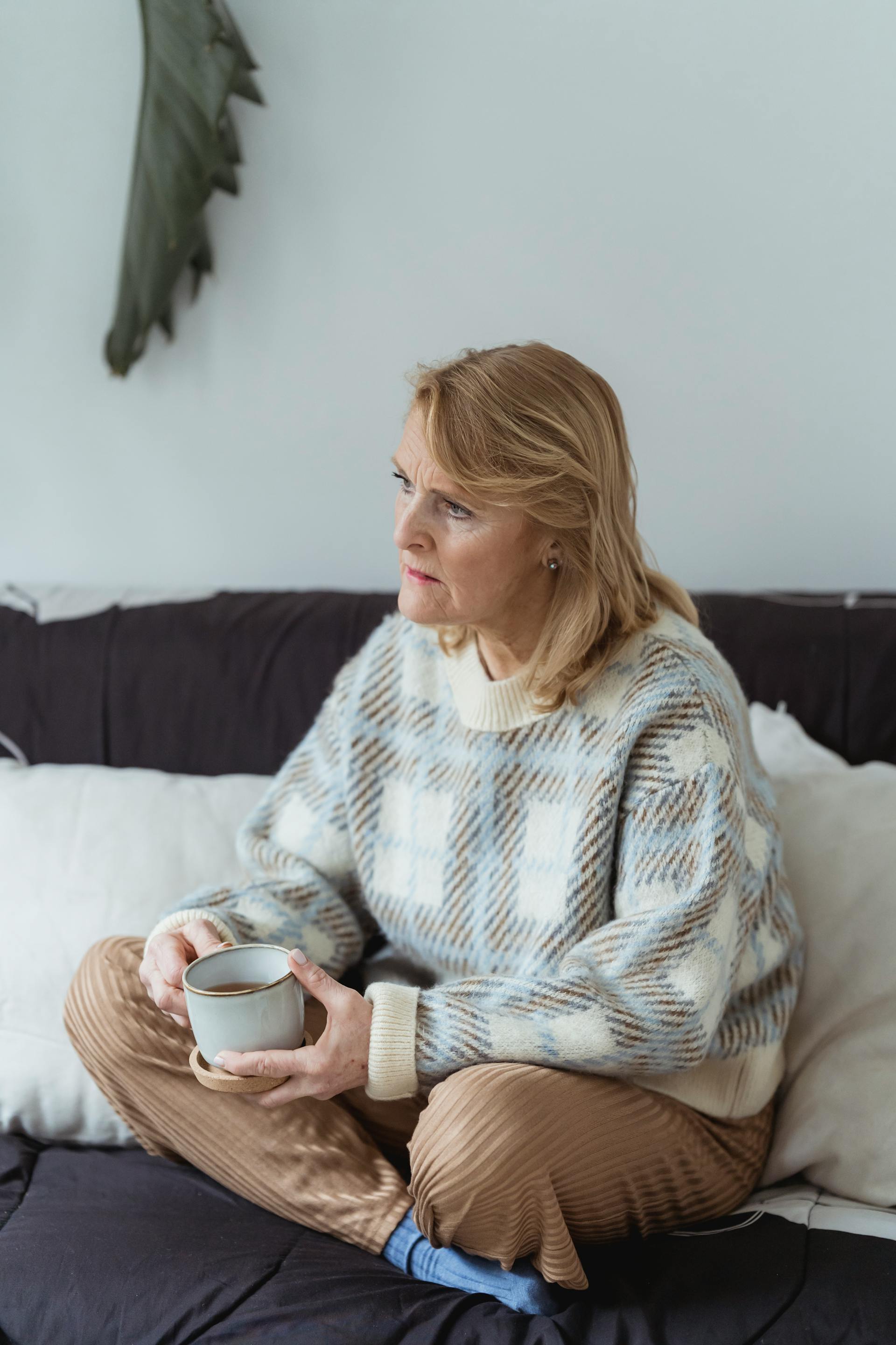 Una mujer de mediana edad con una taza en la mano y mirando a alguien | Fuente: Pexels
