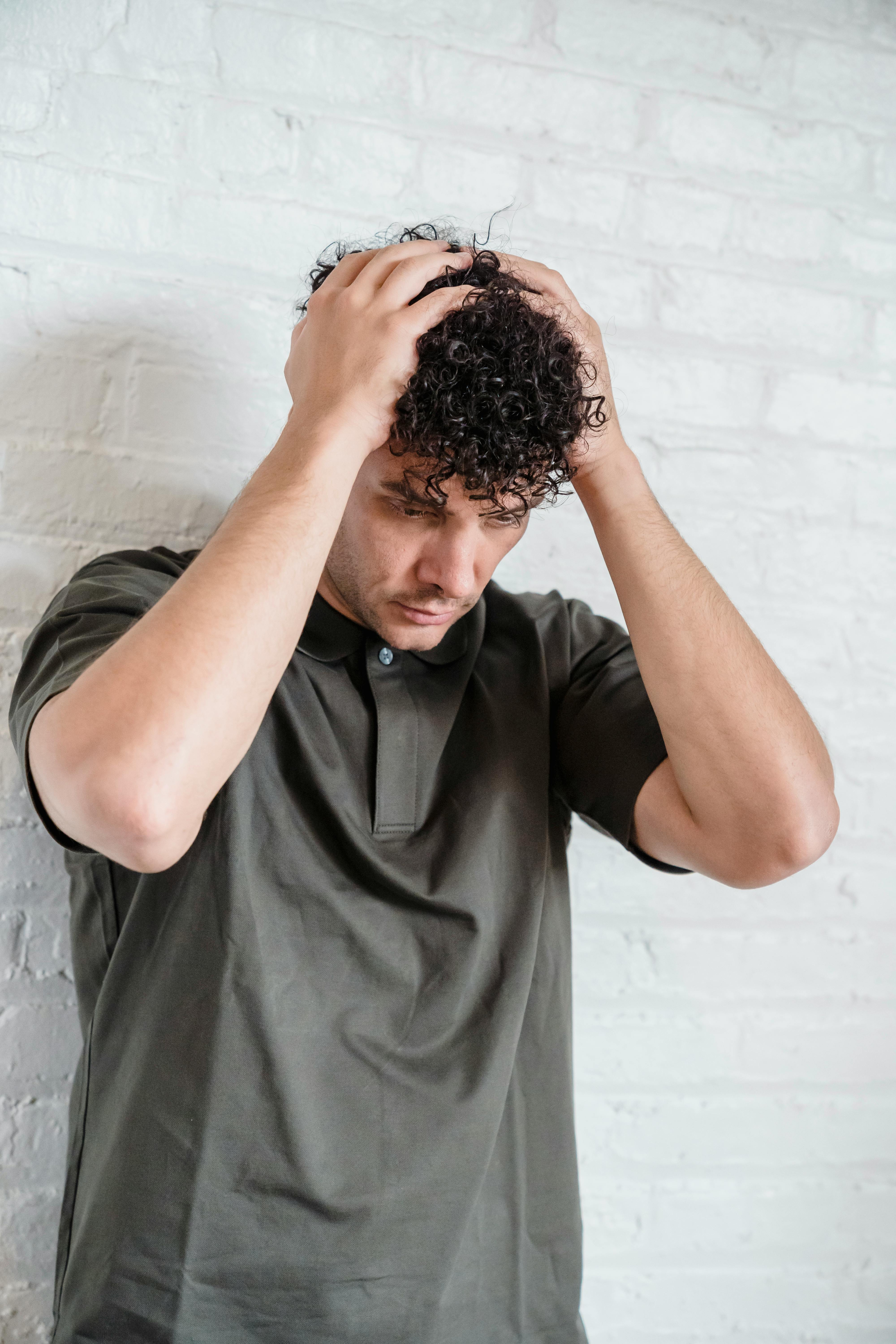 Un hombre sujetándose la cabeza | Fuente: Pexels