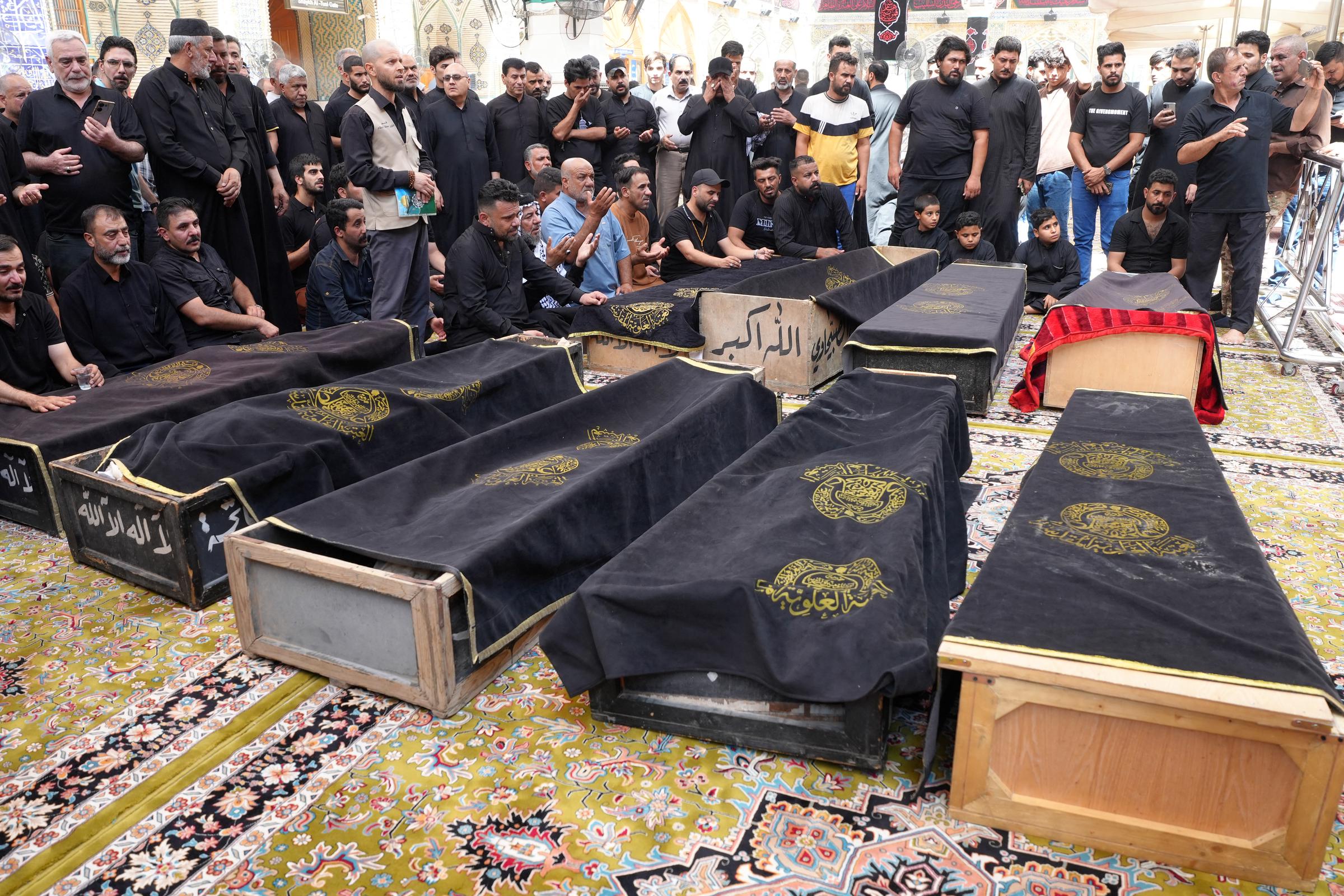 Decenas de personas se reúnen para llorar alrededor de los ataúdes de varias víctimas del incendio del Hyper Mall en Kut, Irak, el 17 de julio de 2025. | Fuente: Getty Images