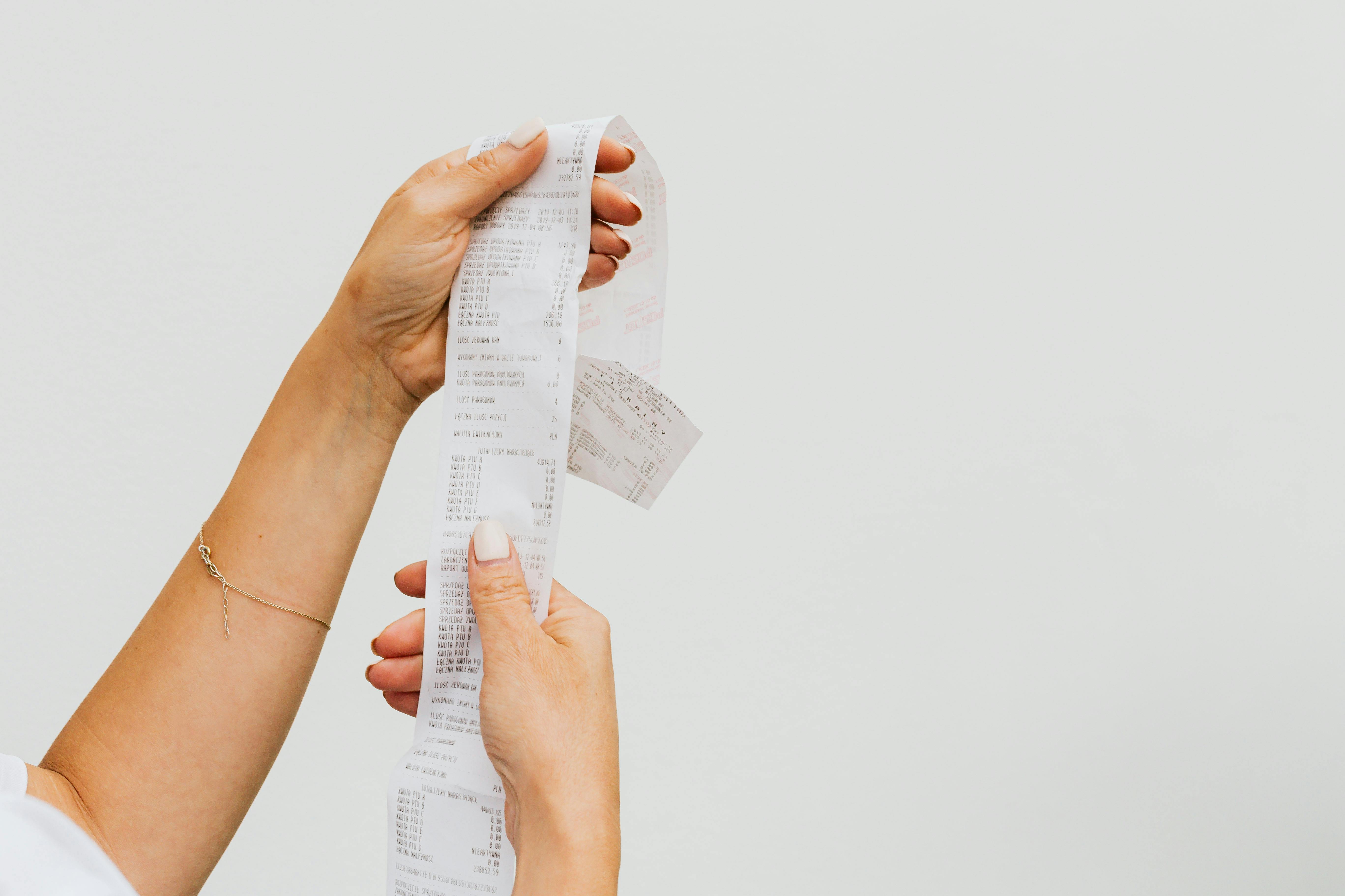 Una persona con un recibo en la mano | Fuente: Pexels