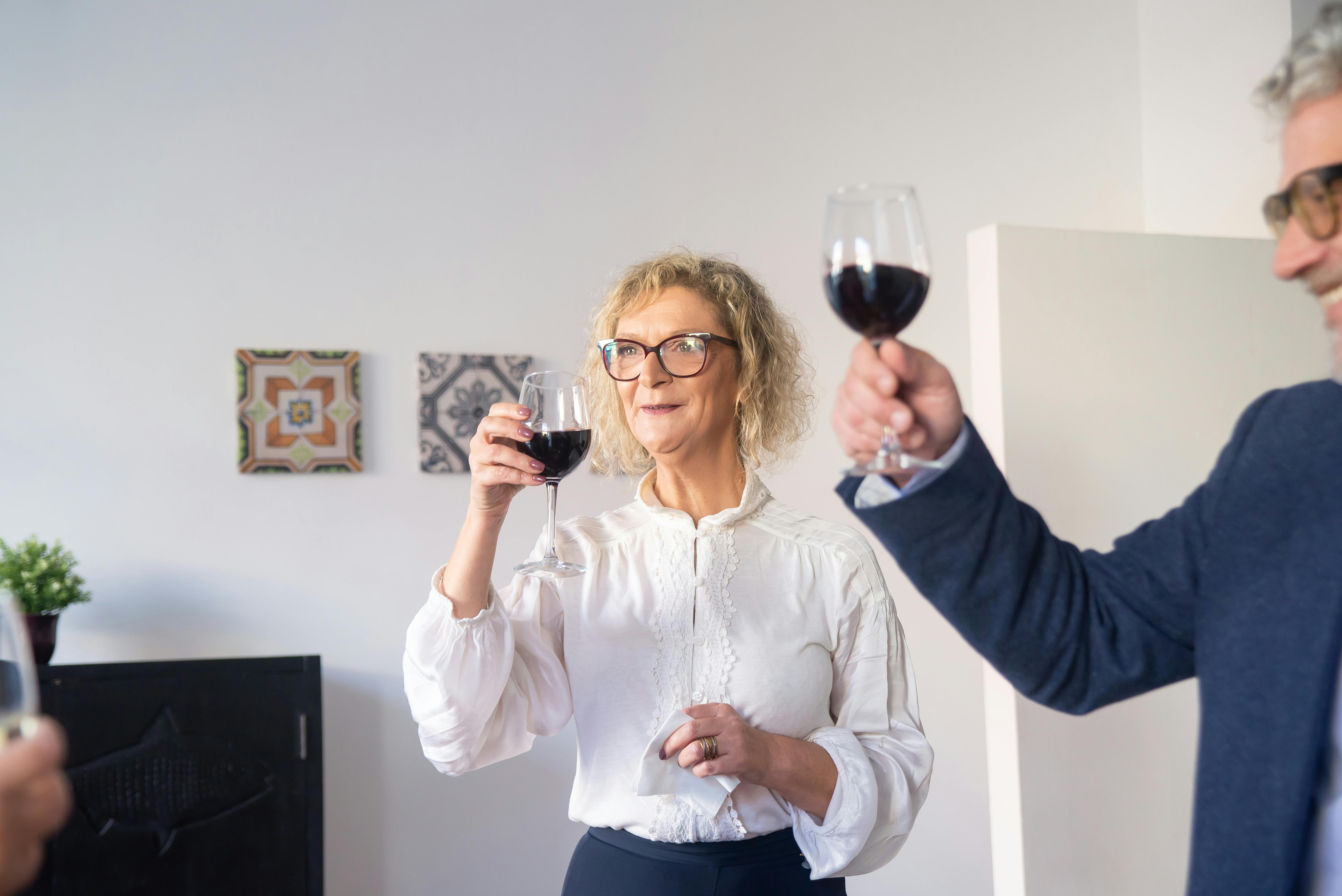Un hombre y una mujer sosteniendo copas de vino | Fuente: Pexels