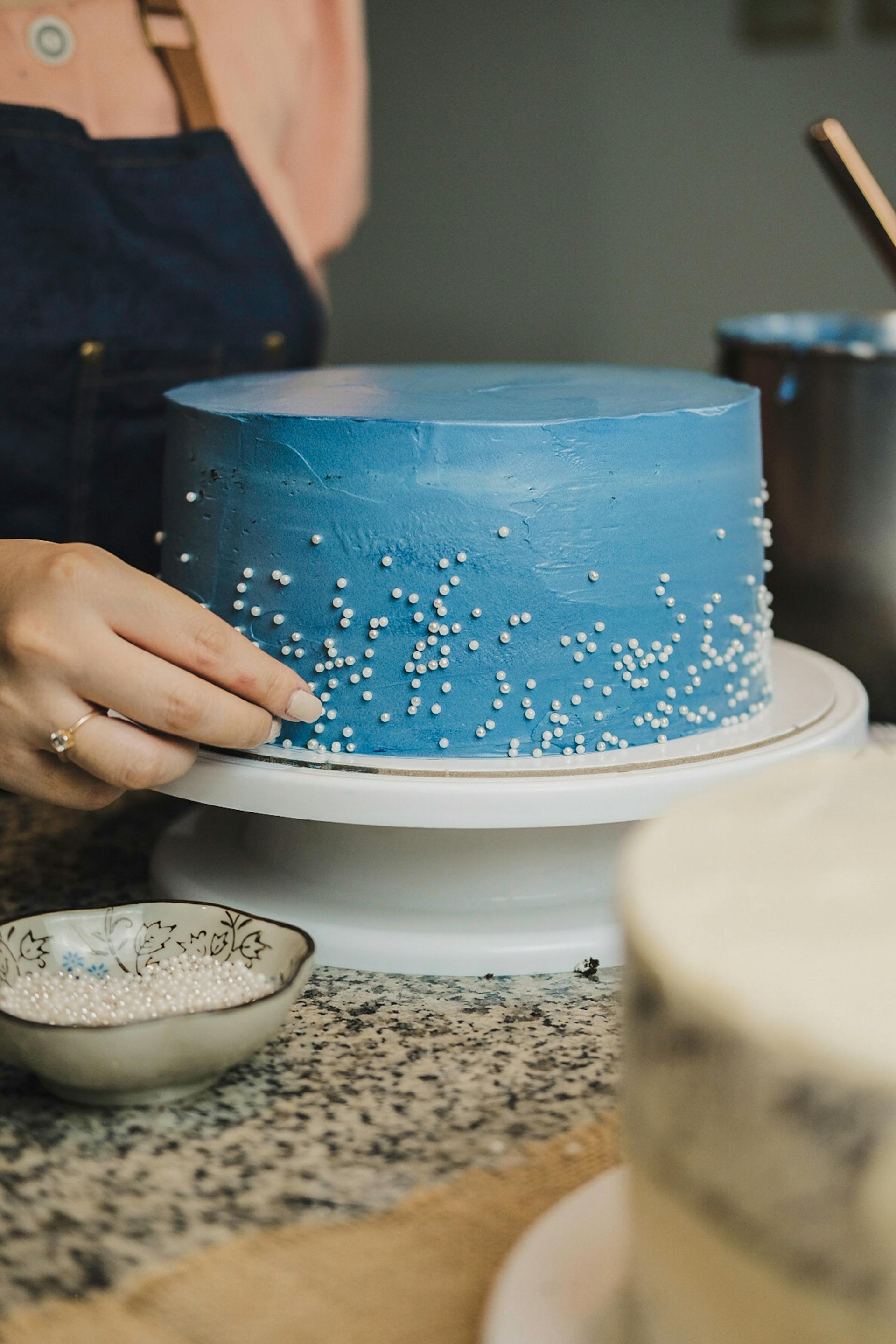 Una mujer decorando un pastel | Fuente: Pexels