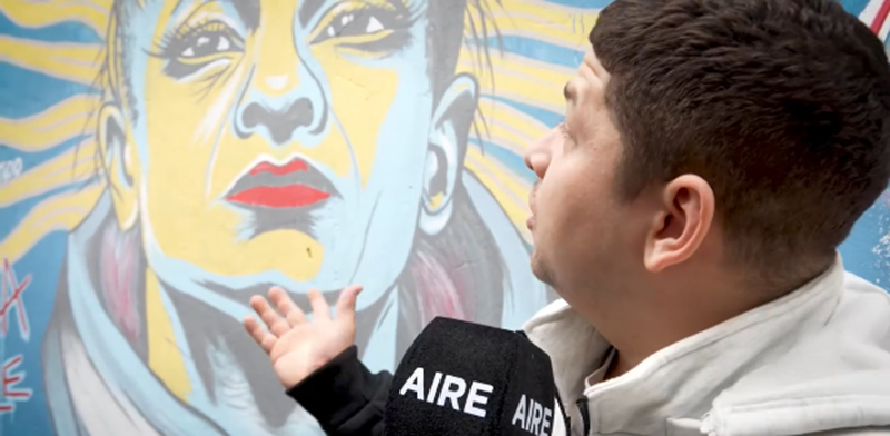 Alexis Oliveras frente al mural realizado por Maxi Henselis en homenaje a Alejandra "Locomotora" Oliveras, ubicado en el gimnasio del barrio Alfonso de Santa Fe, Argentina | Fuente: Instagram/alexis.oliveras.ok