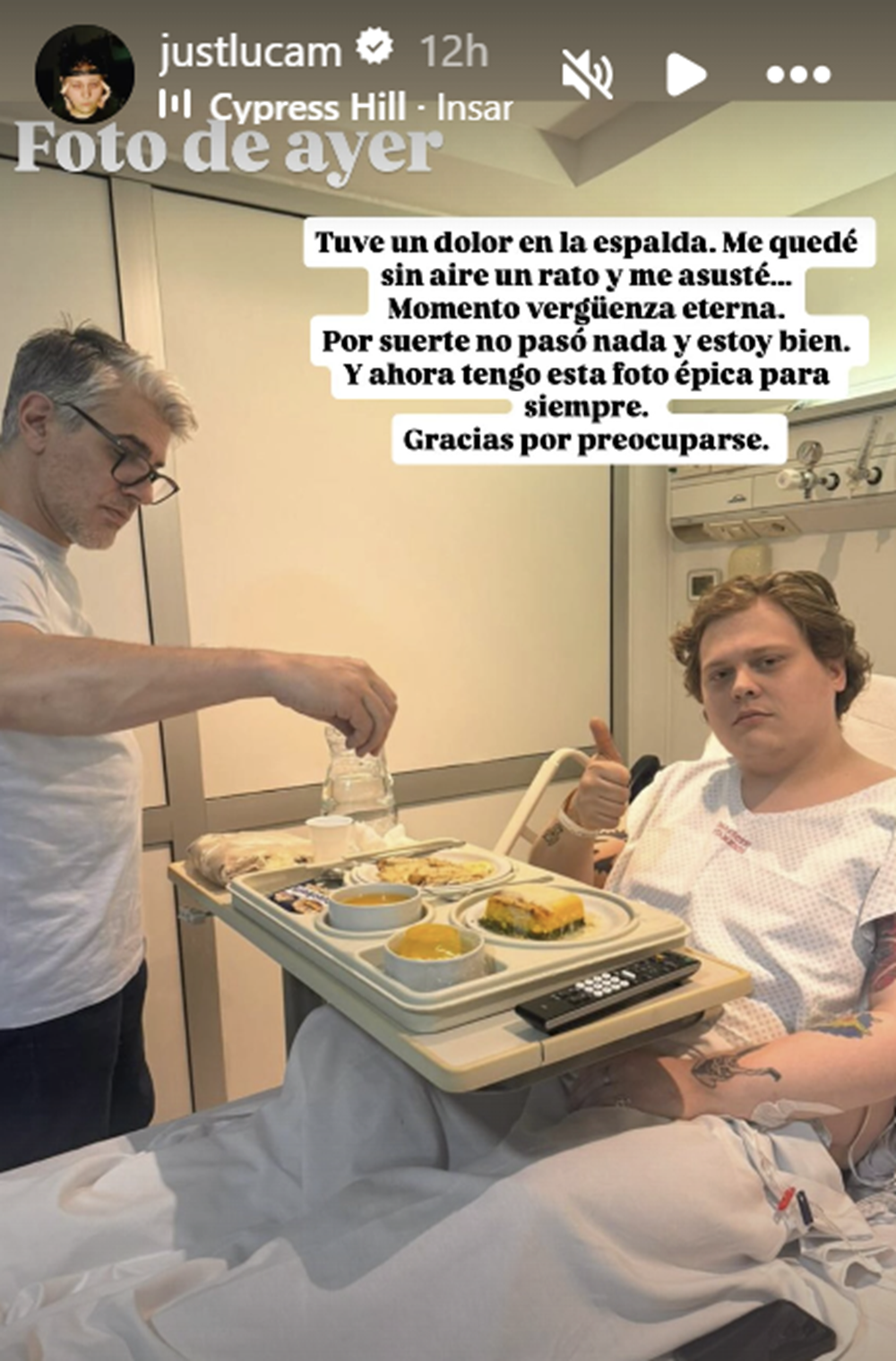 Luca Martin en la cama de un hospital con una bandeja de comida frente a él y saludando a la cámara | Fuente: Instagram Stories/justlucam