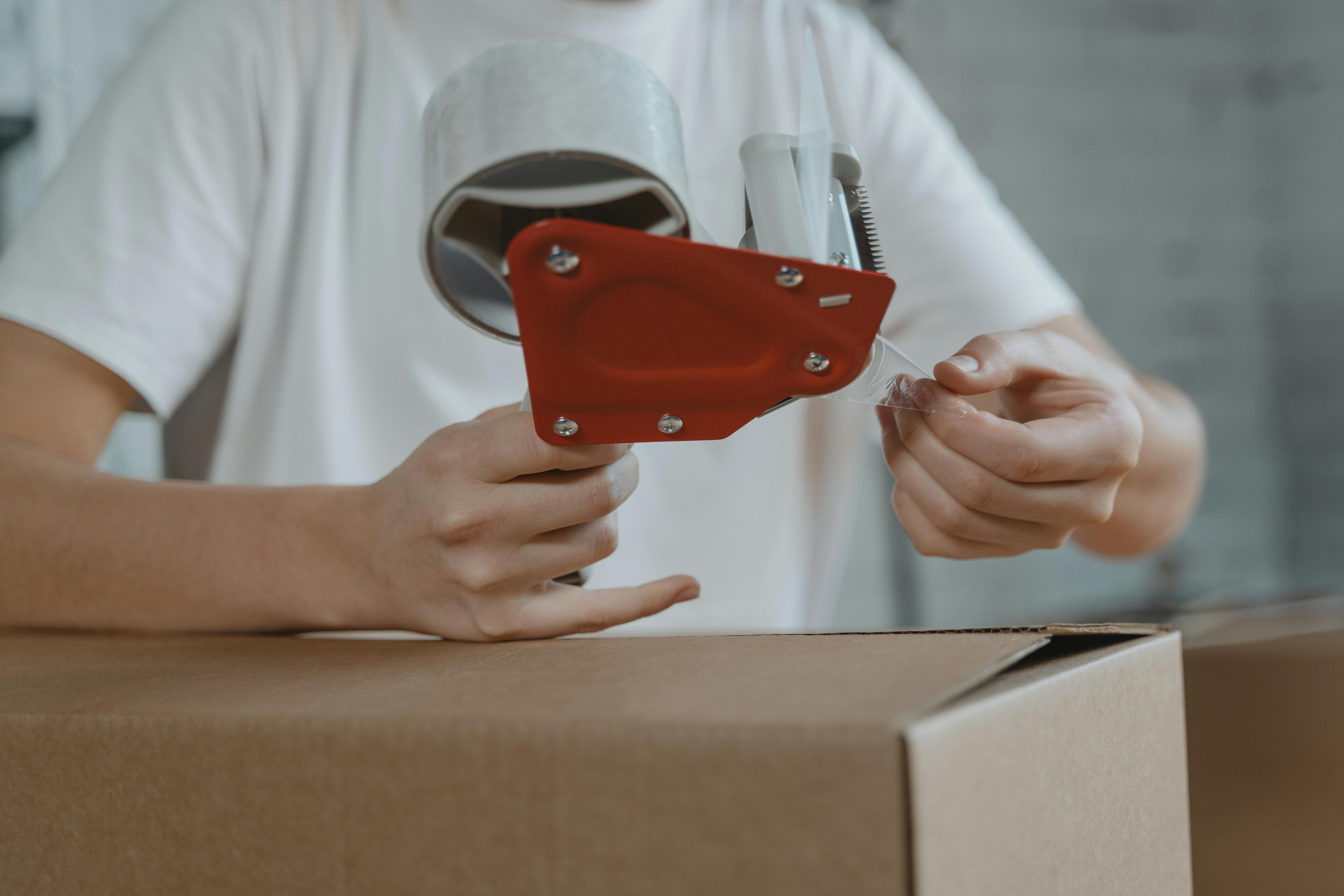 Un hombre sellando una caja | Fuente: Pexels