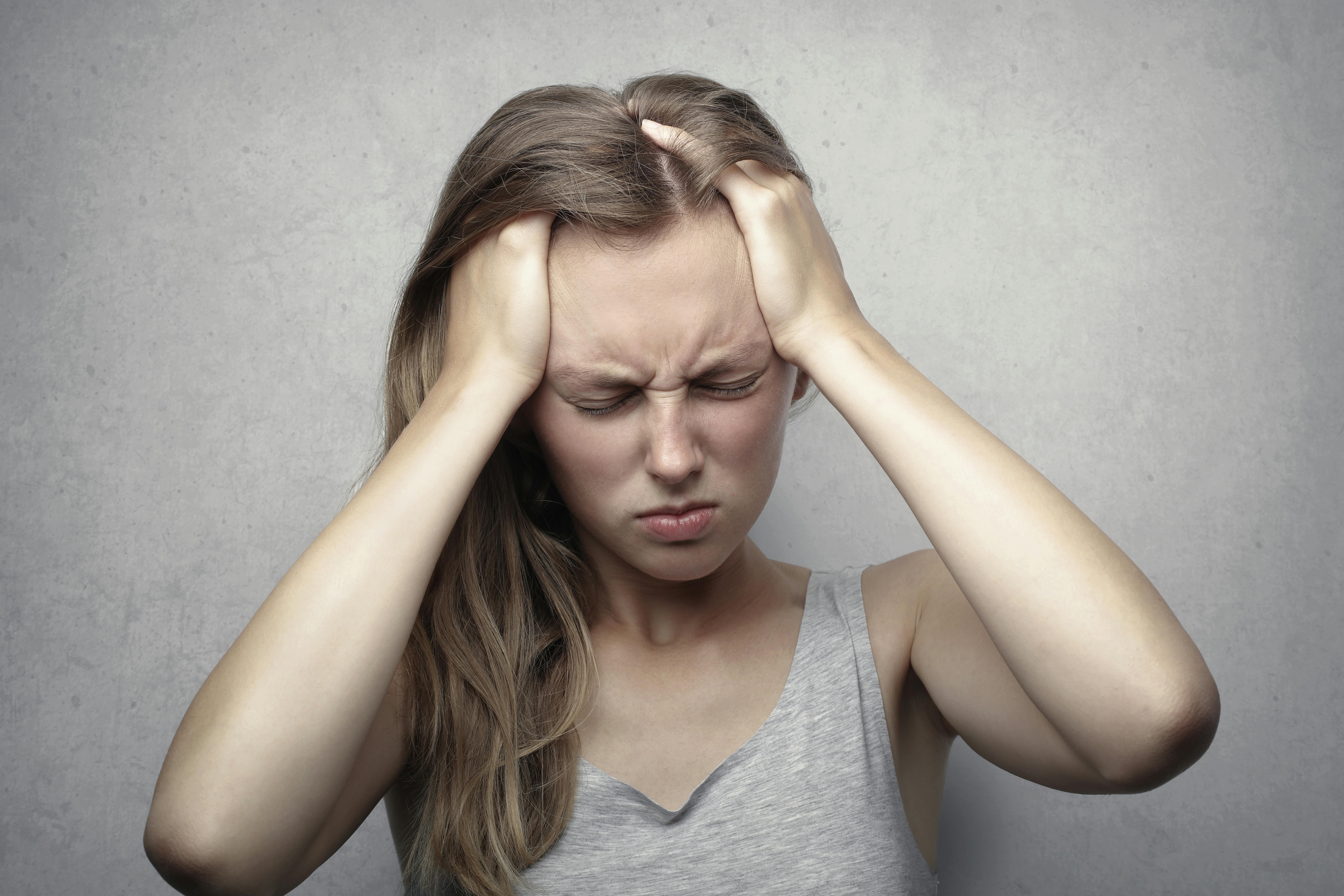Una mujer sujetándose la cabeza | Fuente: Pexels