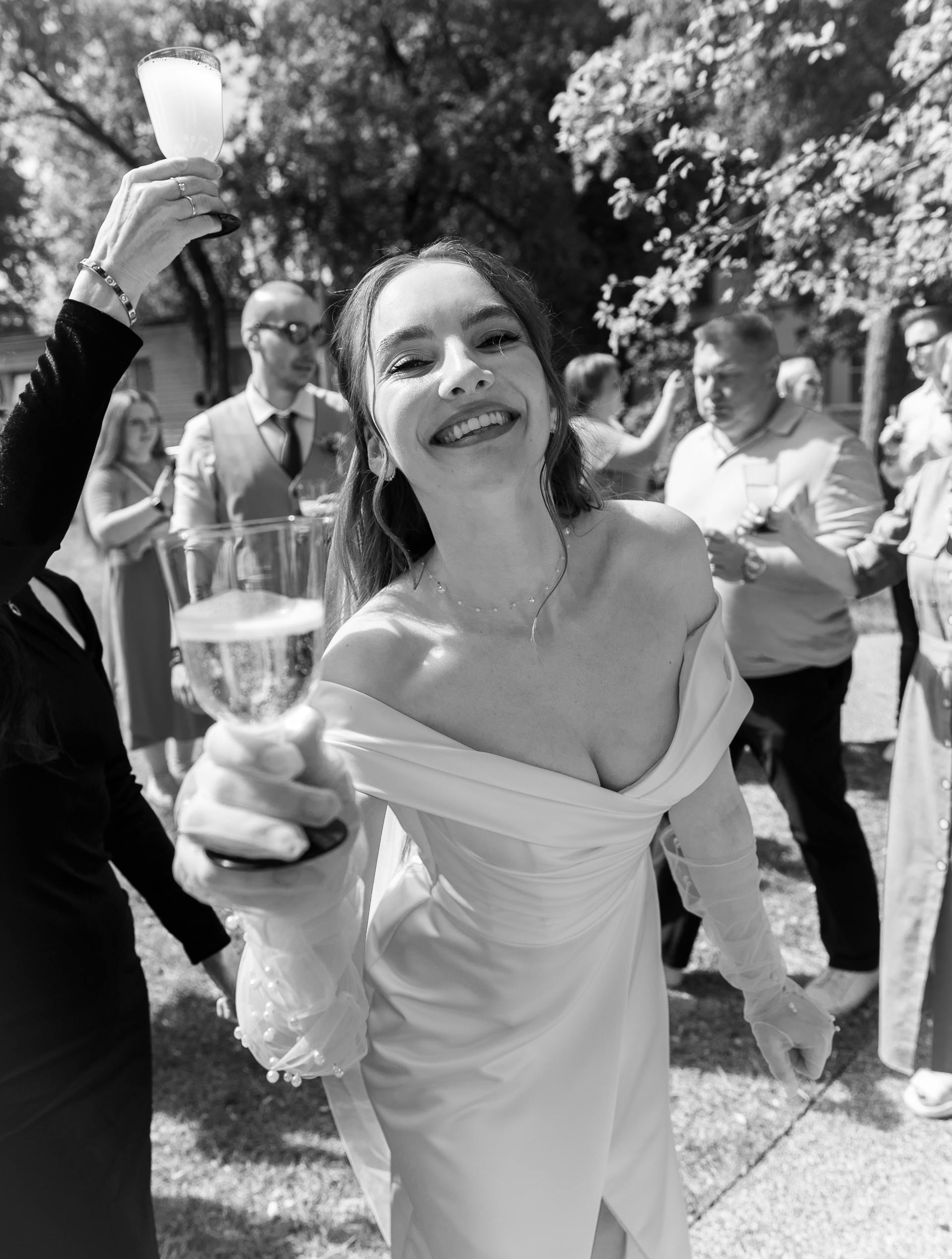 Toma en escala de grises de una novia sonriente con una copa en la mano | Fuente: Pexels