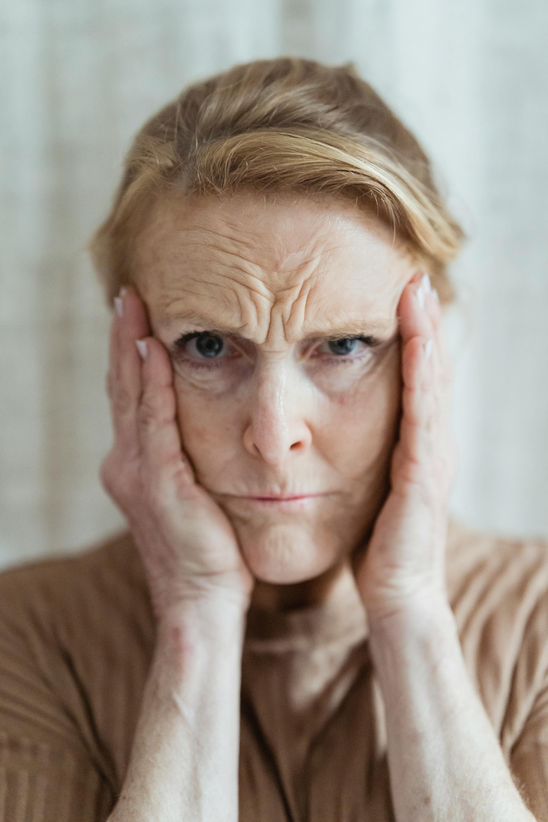 Una mujer de aspecto preocupado se frota las sienes | Fuente: Pexels