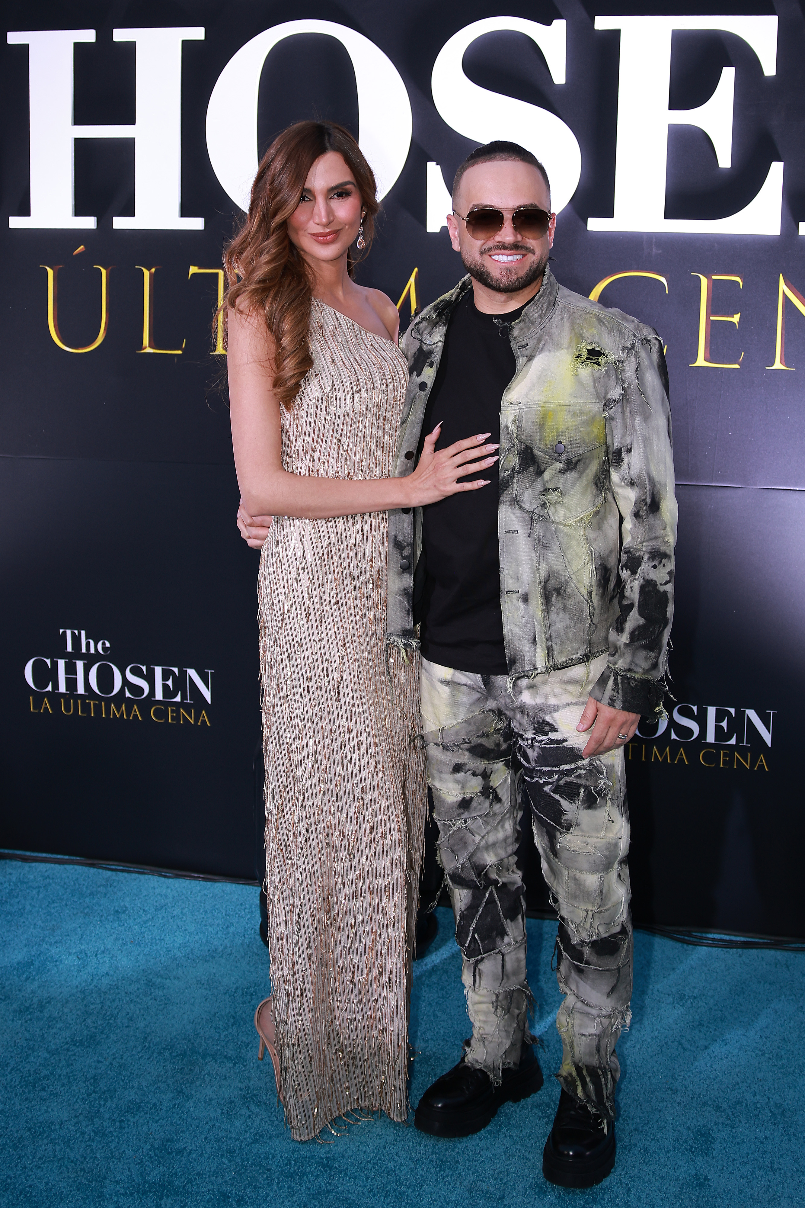 Melany Mille y Miguel Ignacio Mendoza "Nacho" posan para una foto en la alfombra azul turquesa de la serie "The Chosen: Last Supper" en la Plaza Carso el 2 de abril de 2025 en la Ciudad de México, México. | Fuente: Getty Images