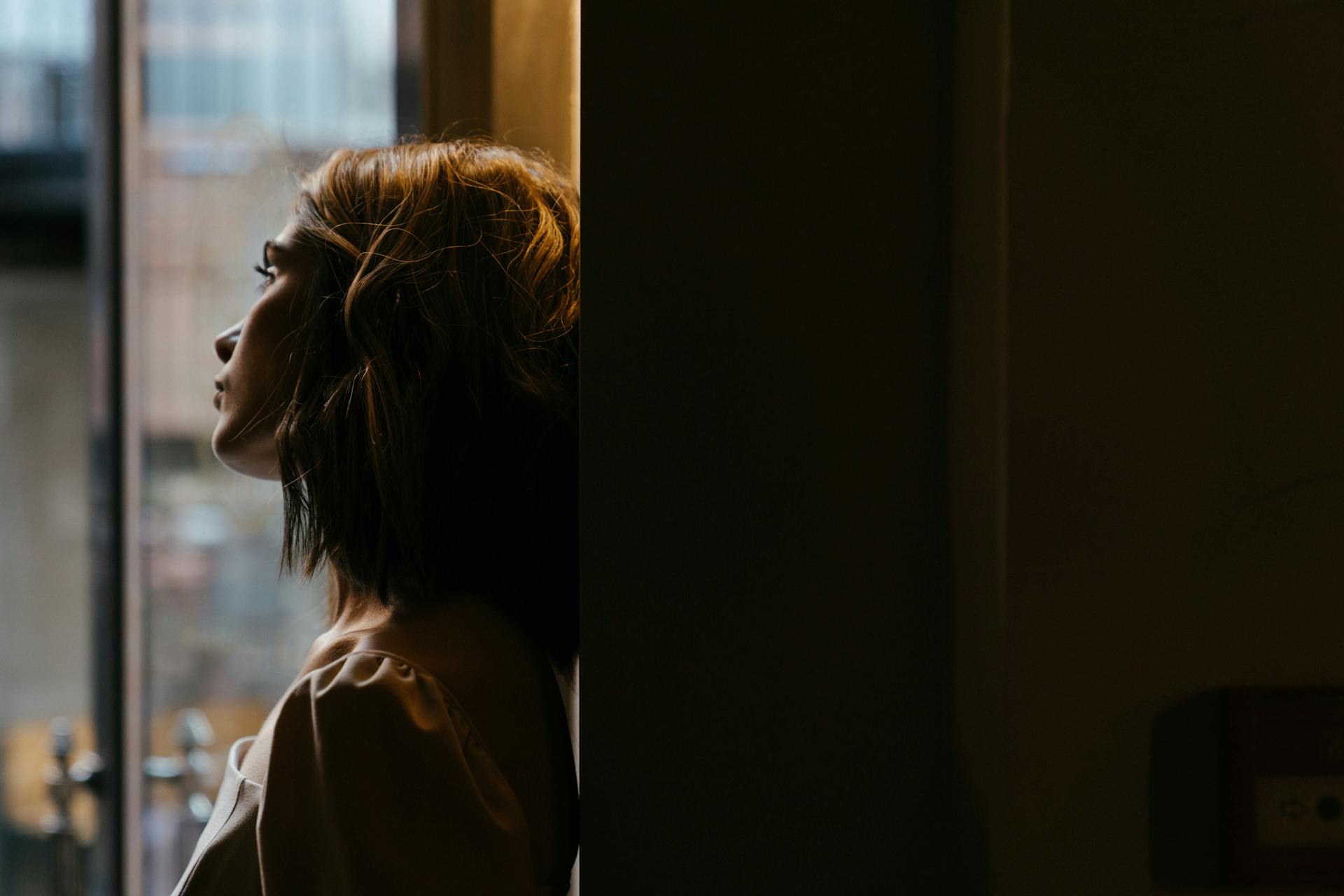 Una mujer mirando por la ventana | Fuente: Pexels