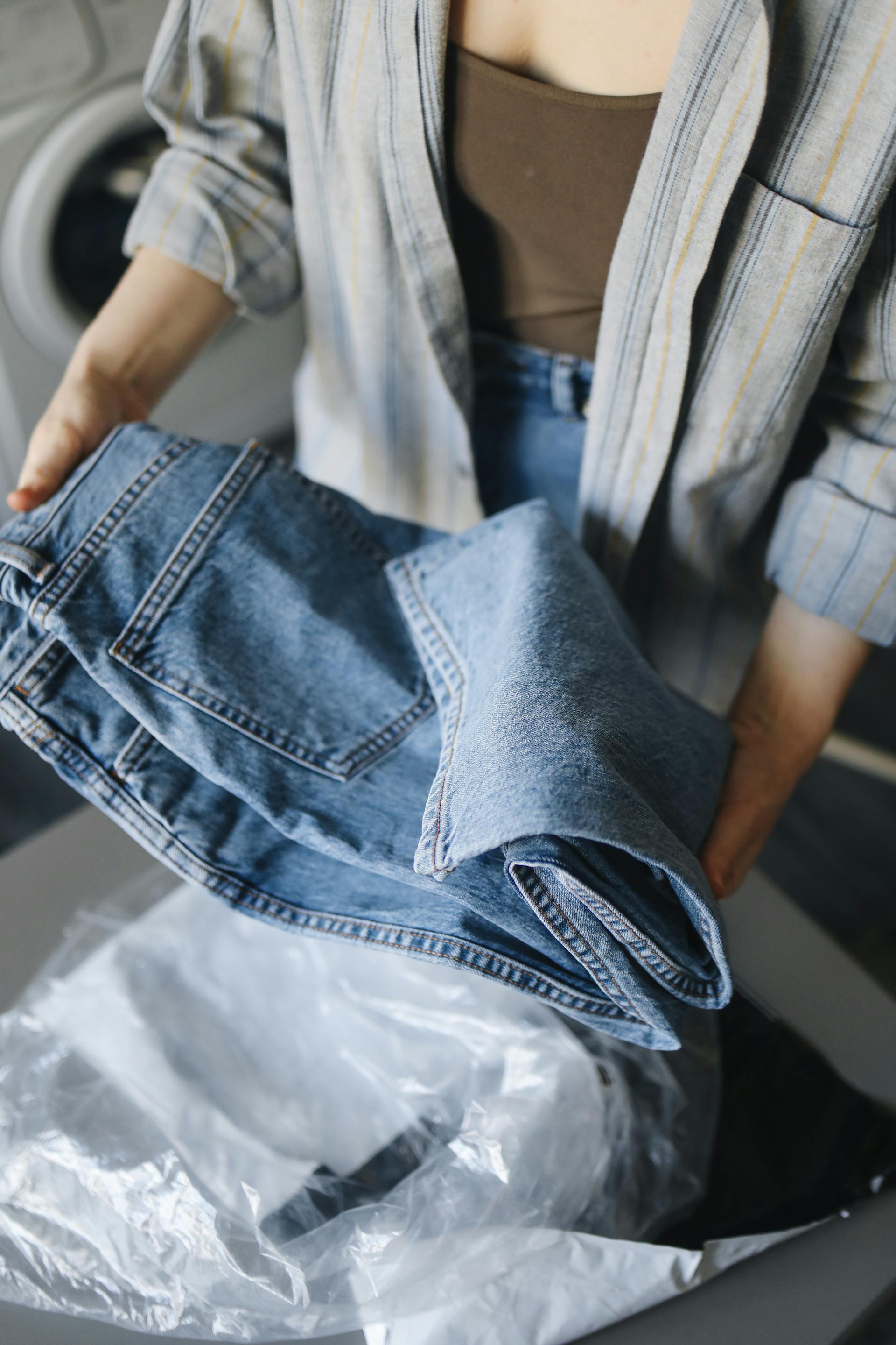 Primer plano de una mujer sujetando unos vaqueros azules | Fuente: Pexels