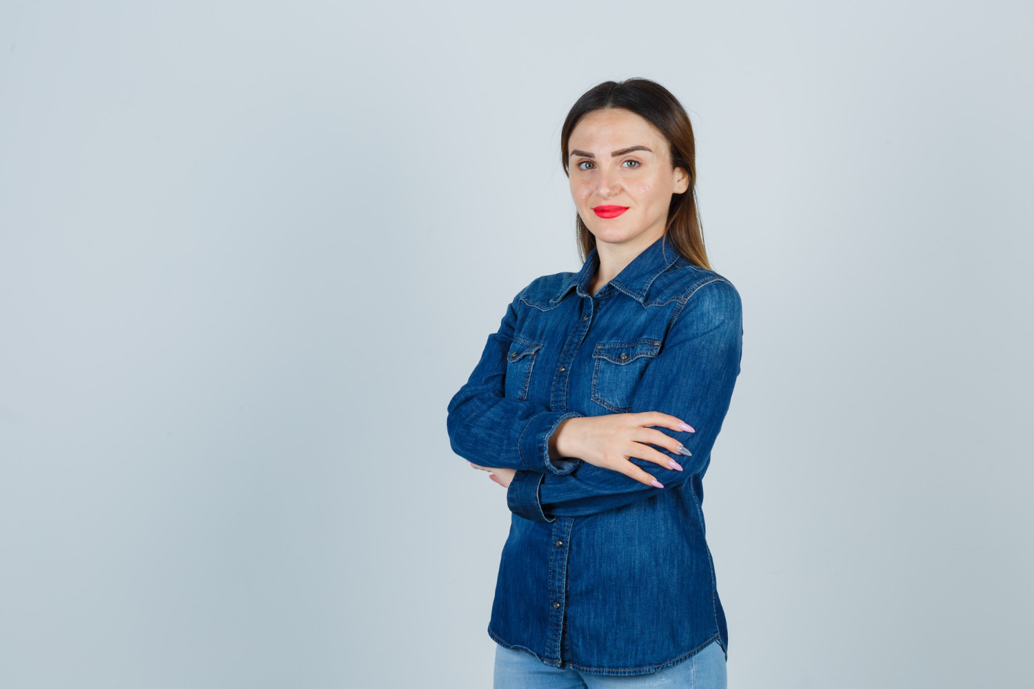 Una mujer sonriente con los brazos cruzados | Fuente: Freepik