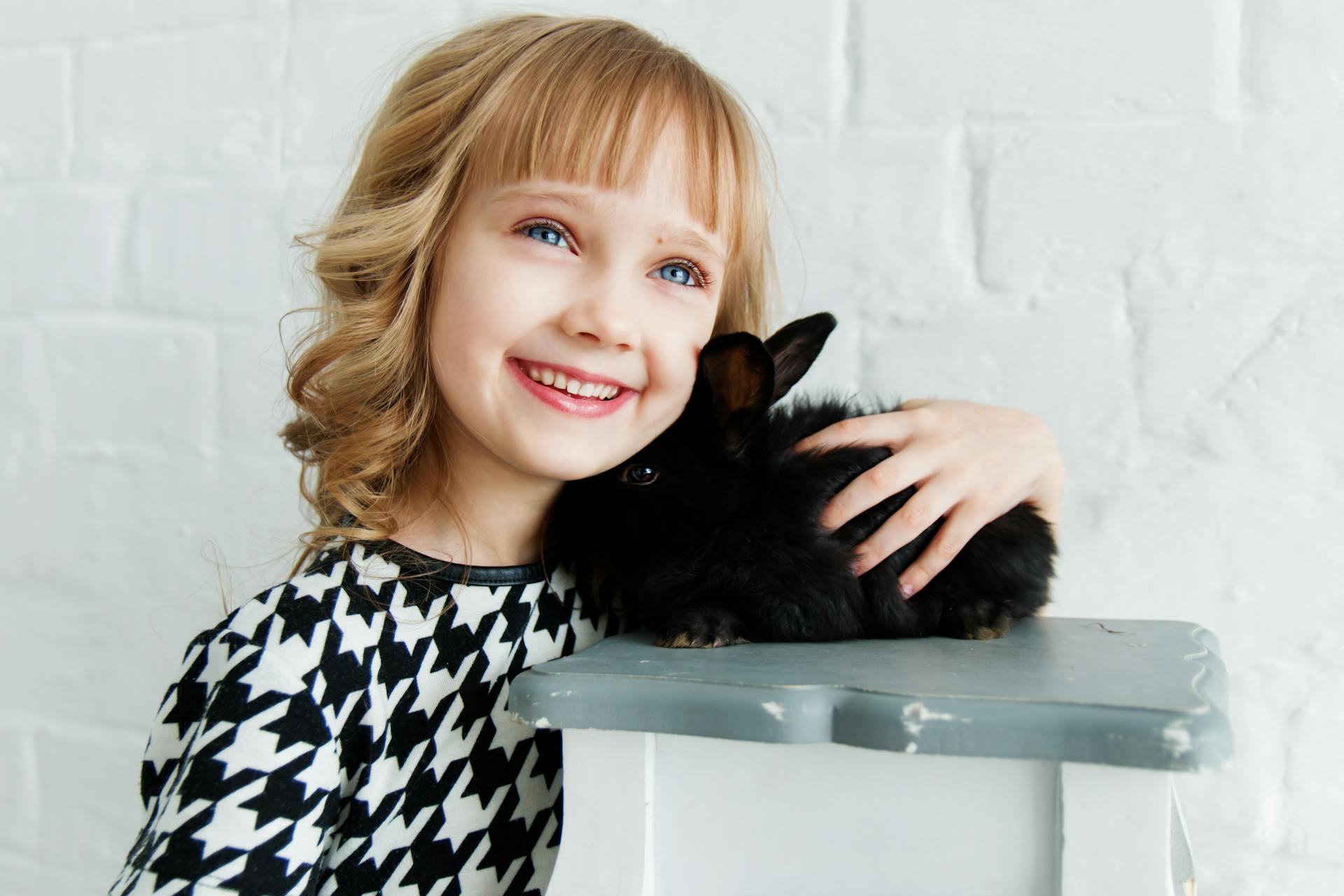 Una niña encantada con su conejo | Fuente: Pexels