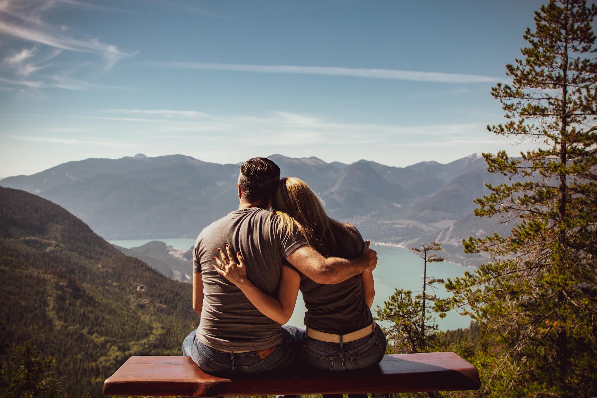 Una pareja sentada en un banco y disfrutando de las vistas | Fuente: Pexels