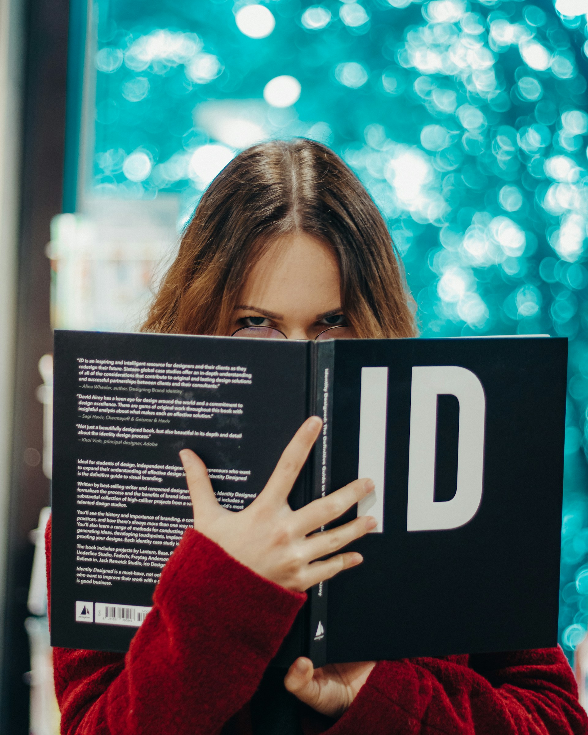Una joven sosteniendo un libro y mirando fijamente | Fuente: Unsplash