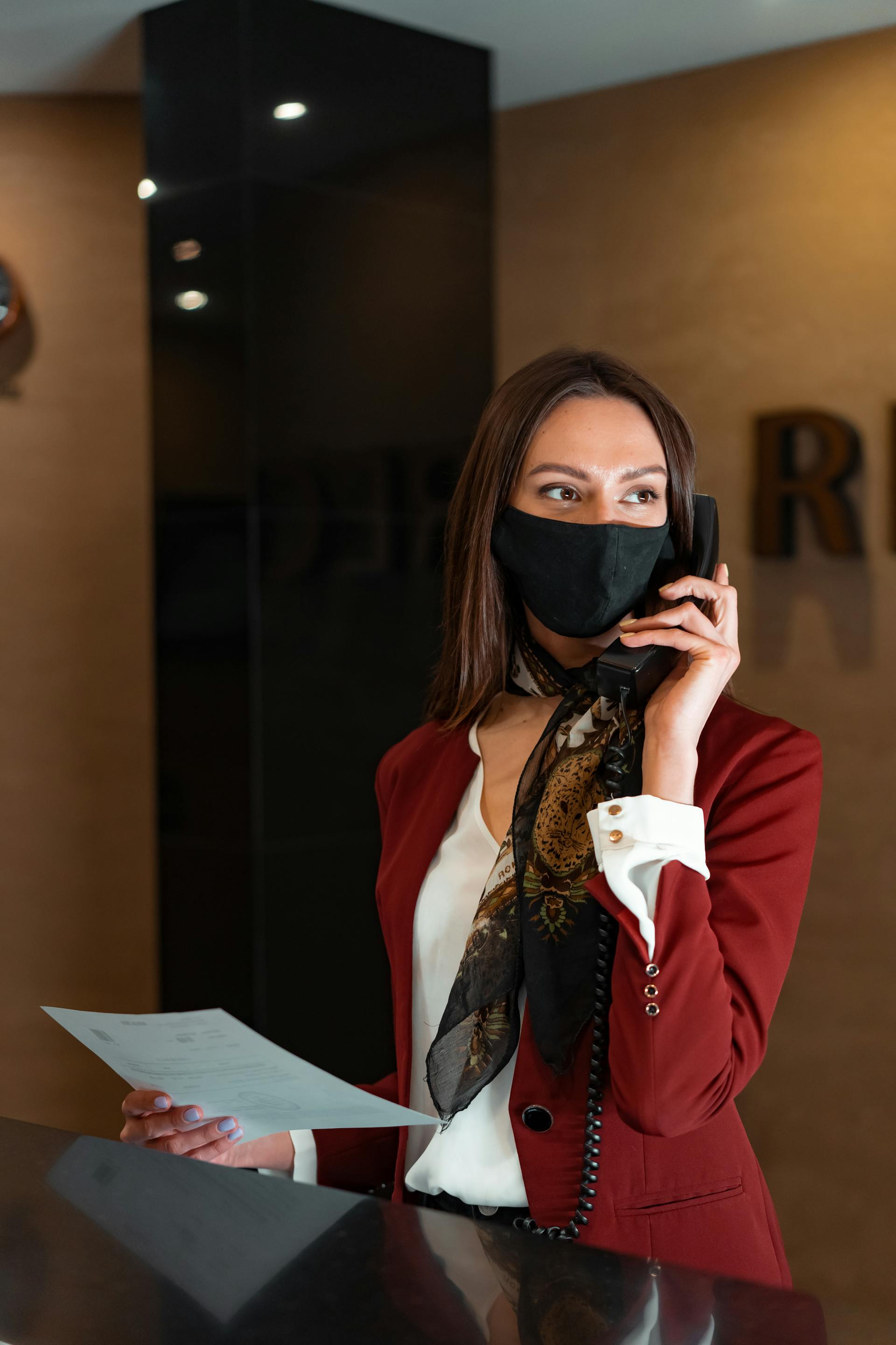 Una recepcionista de hotel hablando por teléfono | Fuente: Pexels