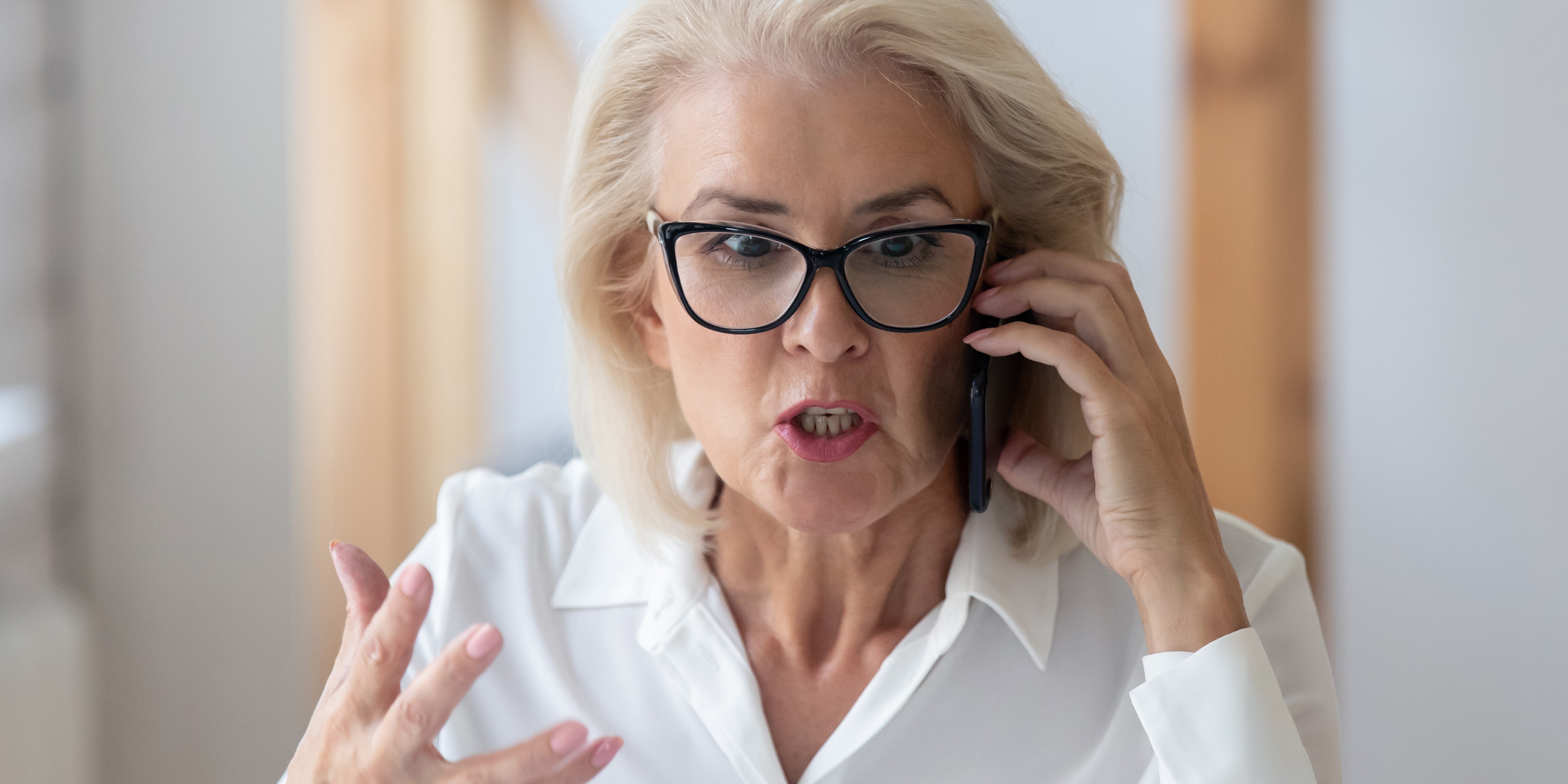 Una mujer hablando airadamente durante una llamada telefónica | Fuente: Shutterstock