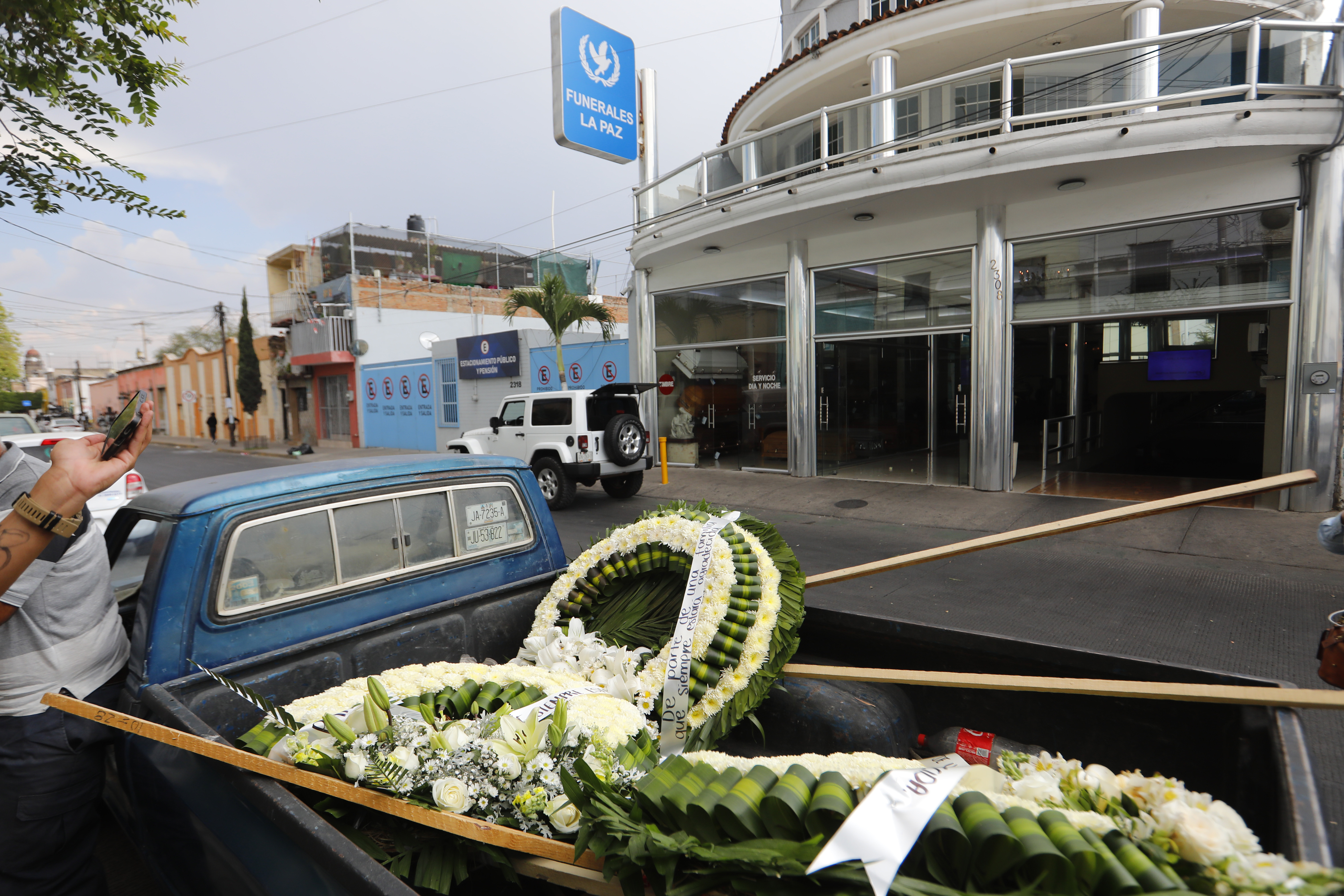 Los empleados descargan un arreglo floral afuera de la funeraria de La Paz mientras miembros del Ejército Mexicano toman medidas de seguridad cerca de la funeraria, donde se cree que se encuentra el cuerpo de Nemesio Oseguera Cervantes, líder del Cártel Jalisco Nueva Generación (CJNG) conocido como 'El Mencho', en Guadalajara, Jalisco, México, el 1 de marzo de 2026. | Fuente: Getty Images.