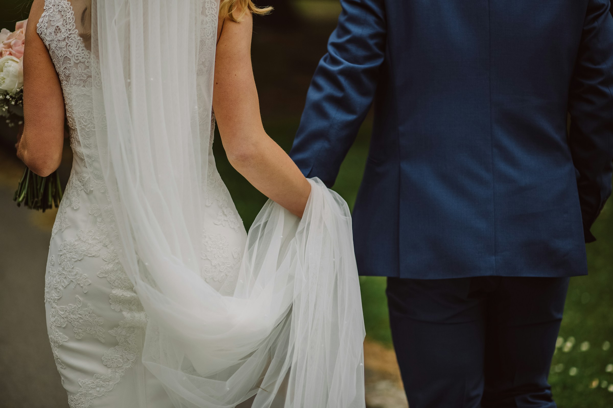 Una novia y un novio tomados de la mano mientras caminan | Fuente: Unsplash