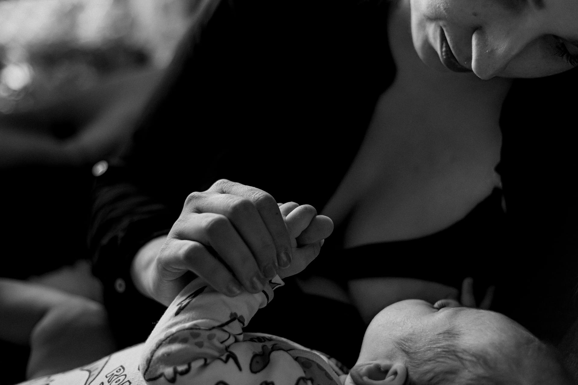 Foto en escala de grises de una mujer con su bebé en brazos | Fuente: Pexels