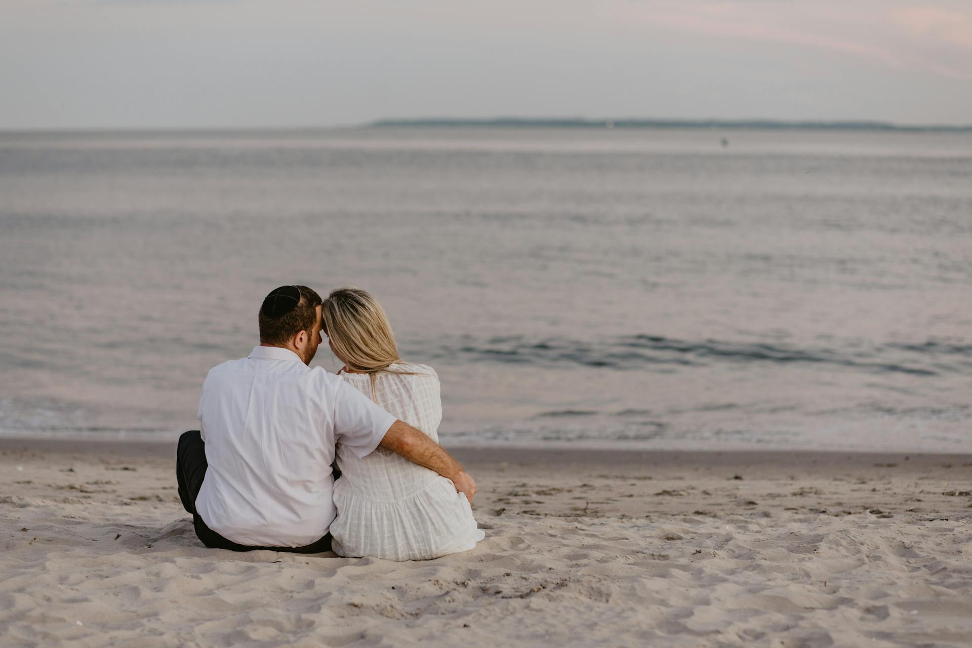 Una pareja sentada en la playa | Fuente: Pexels