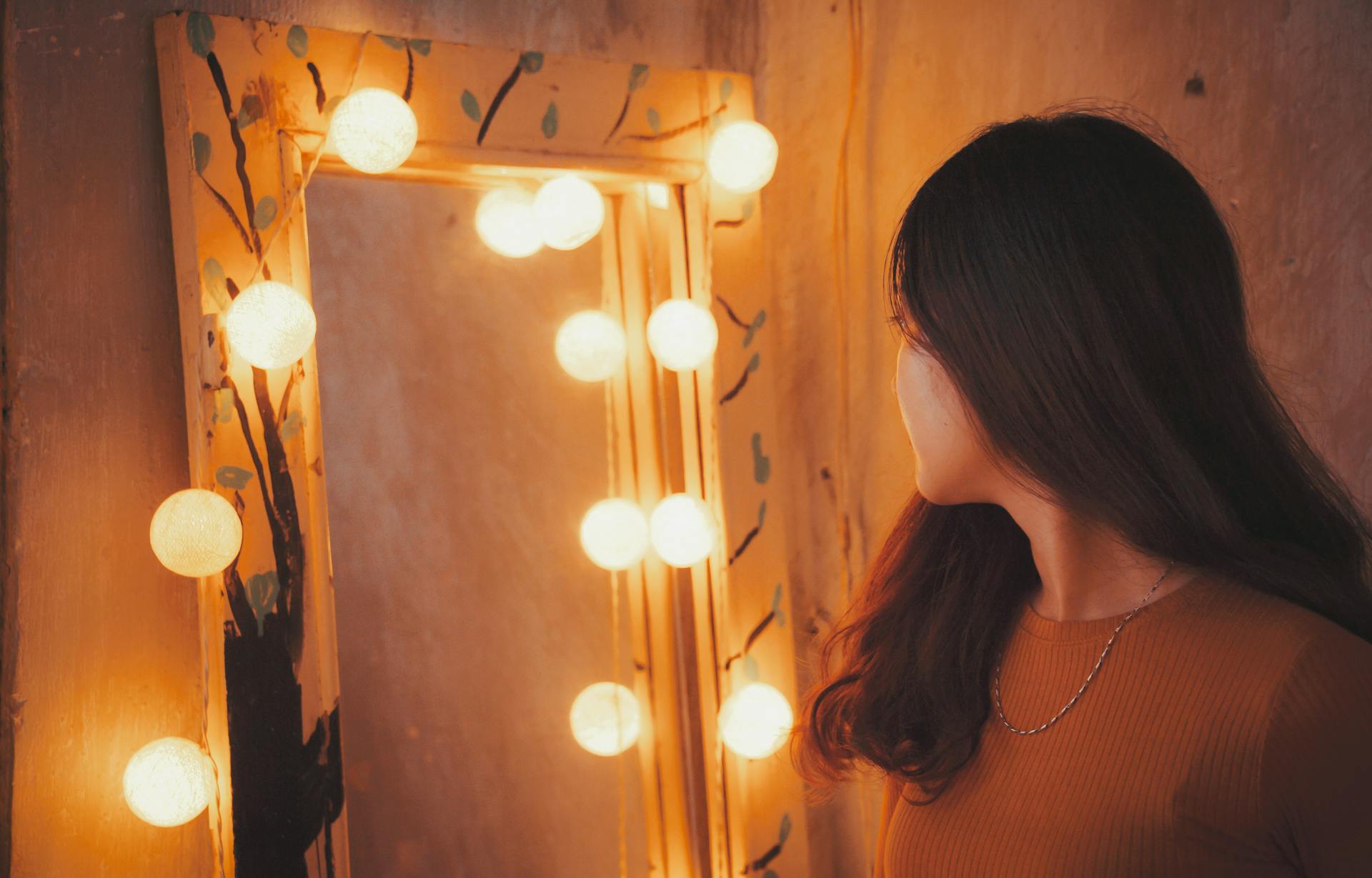 Una mujer mirándose en un espejo | Fuente: Pexels