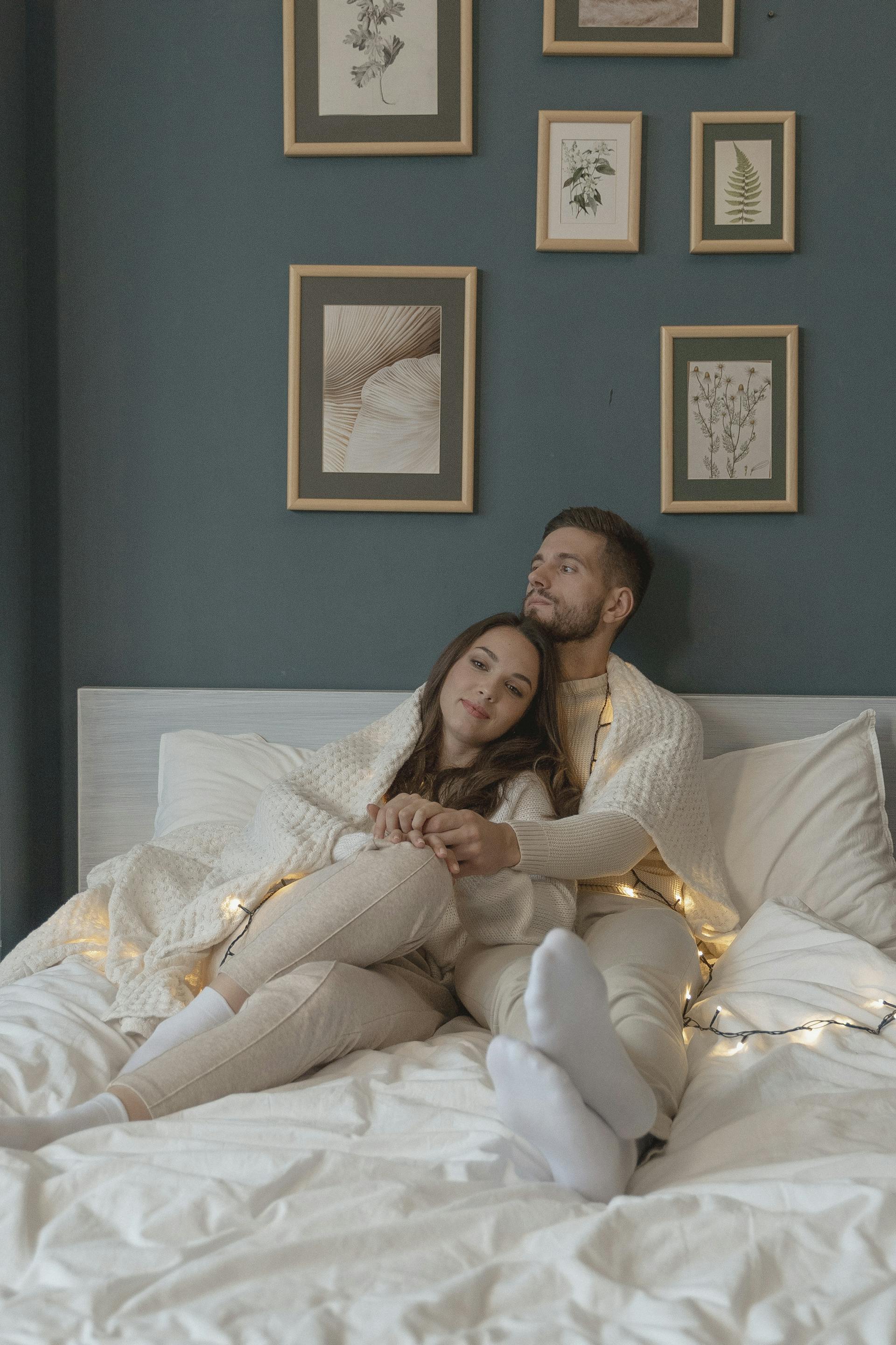 Una pareja sentada junta en la cama | Fuente: Pexels