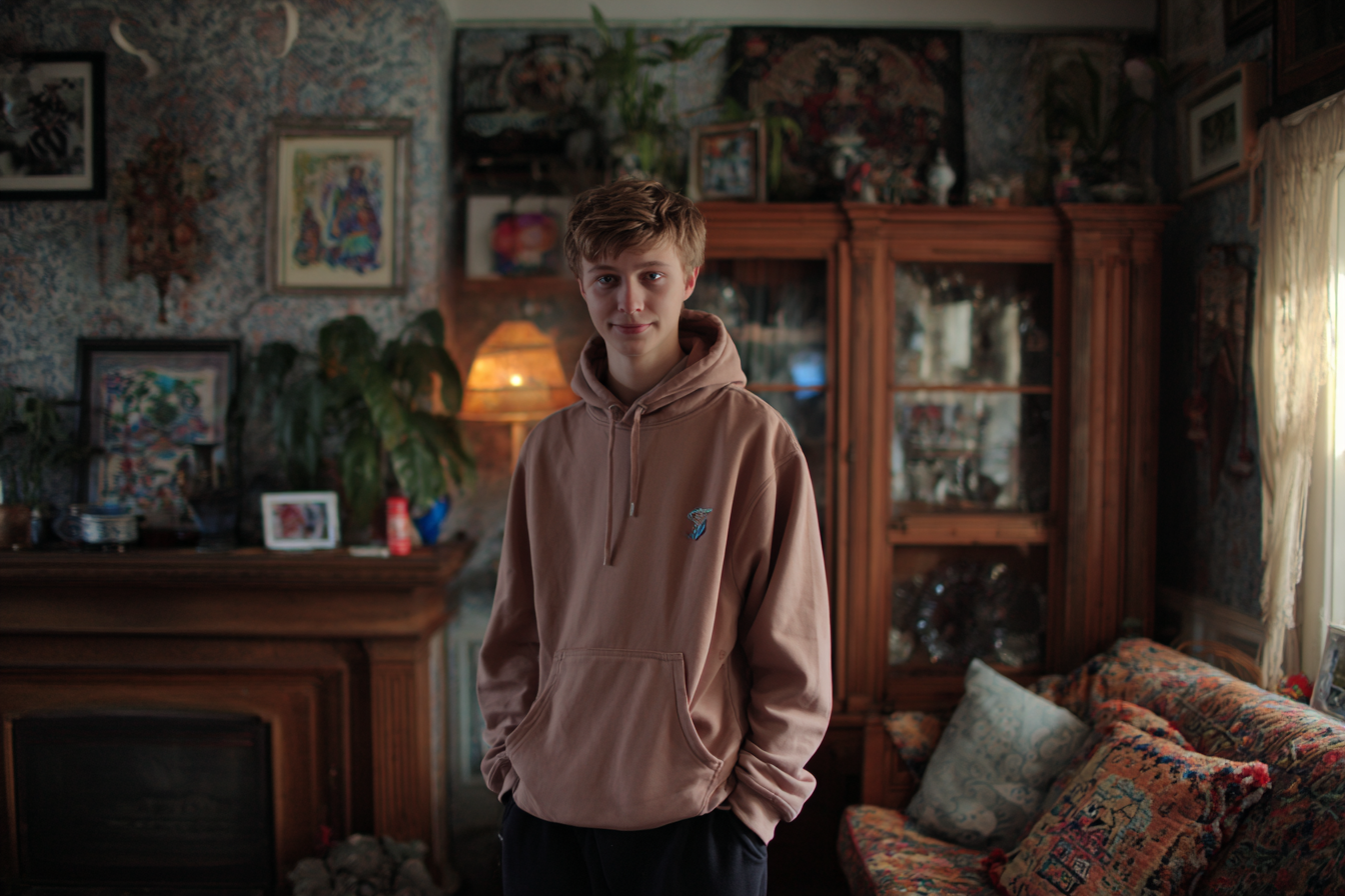Un adolescente de pie en un salón | Fuente: Midjourney