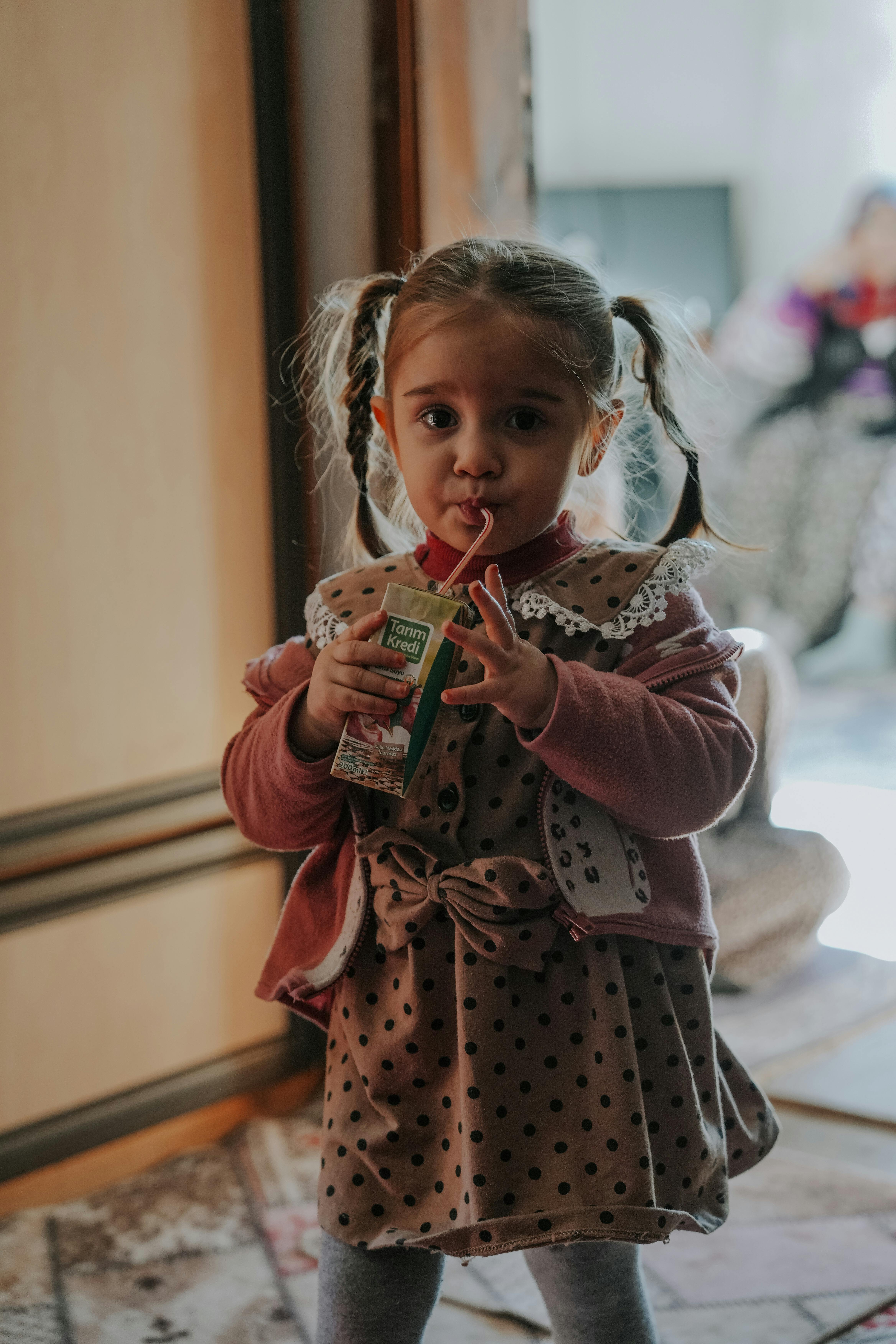 Una niña bebiendo de una caja de zumo | Fuente: Pexels