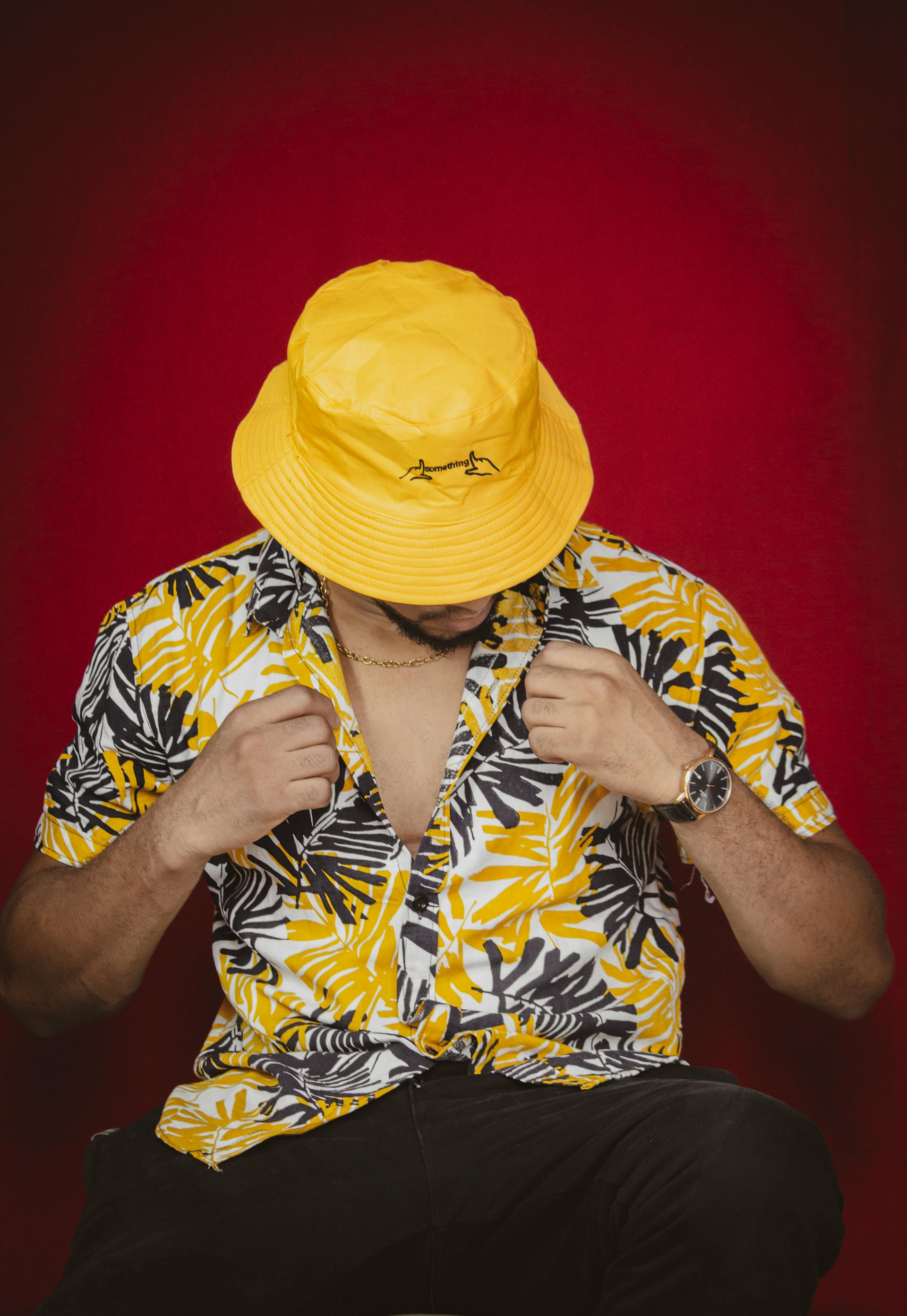 Un hombre con una camisa hawaiana amarilla y un sombrero a juego | Fuente: Pexels
