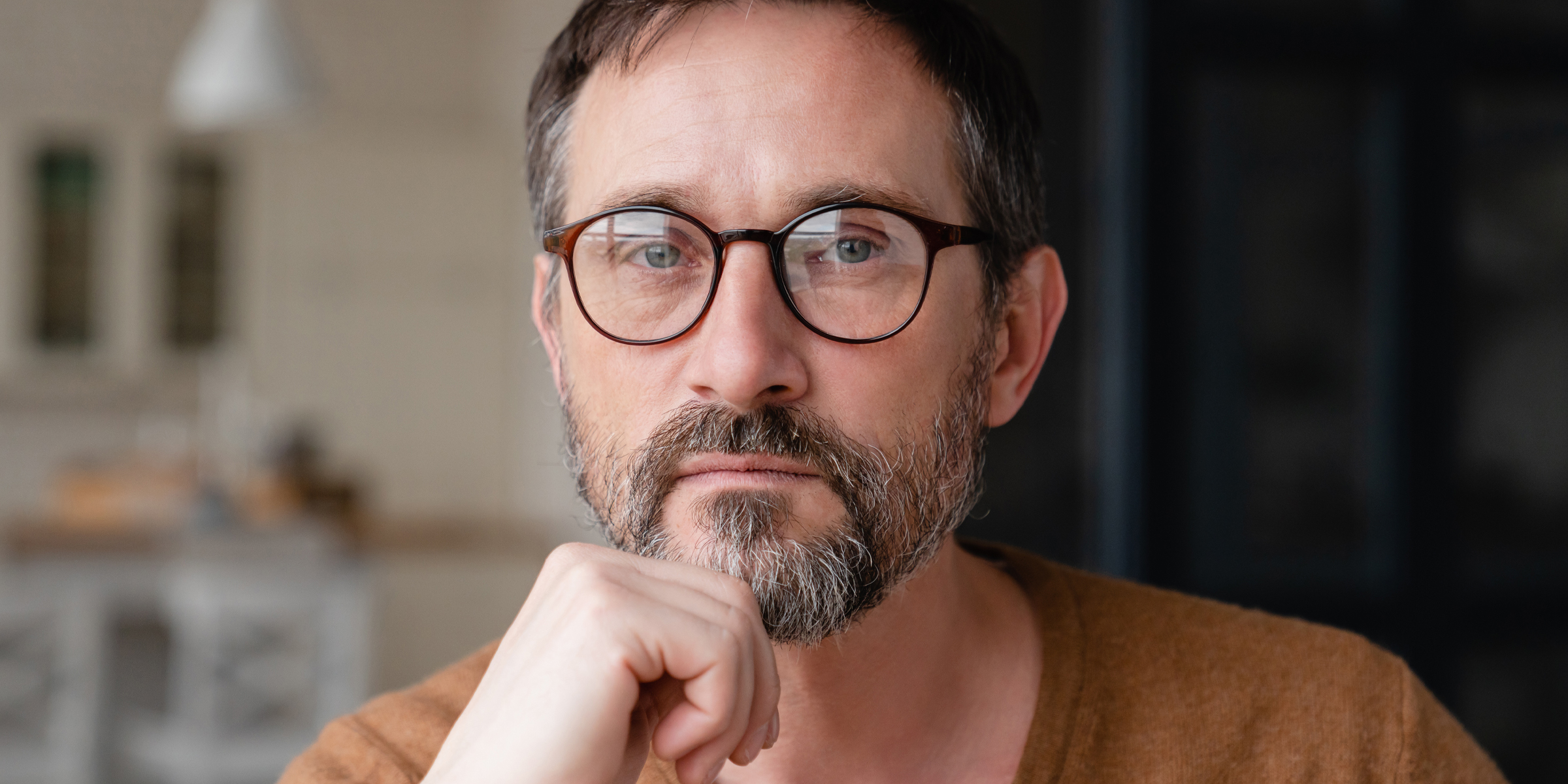 Primer plano de un hombre pensativo con gafas | Fuente: Shutterstock