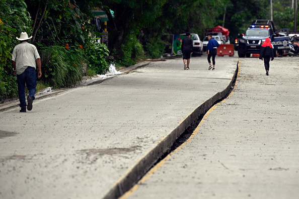 Personas caminan sobre una carretera de asfalto dañada tras las fuertes lluvias en San Bartolo Tutotepec, estado de Hidalgo, México, el 13 de octubre de 2025 | Fuente: Getty Images