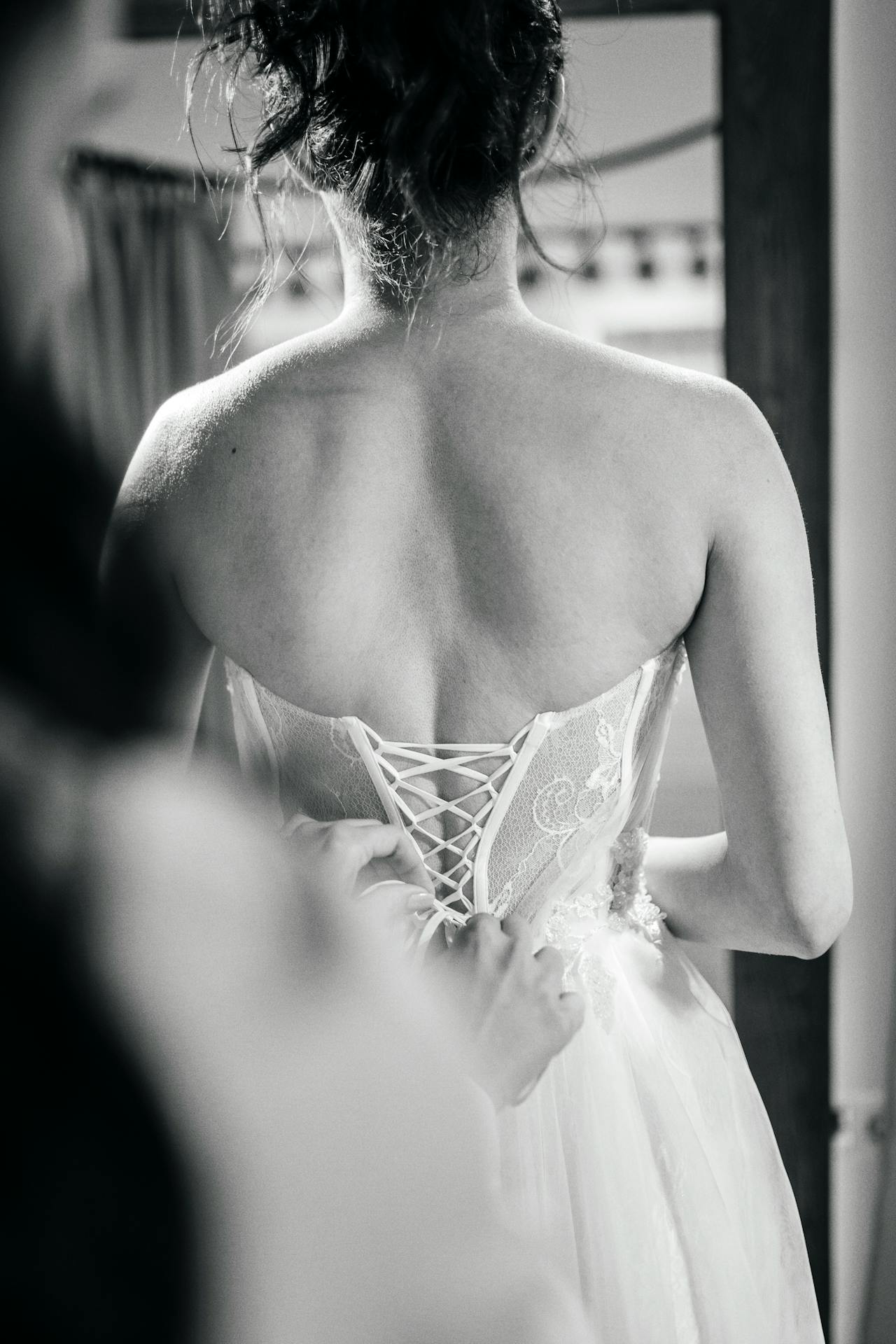 Una mujer ayuda a una novia con su vestido | Fuente: Pexels