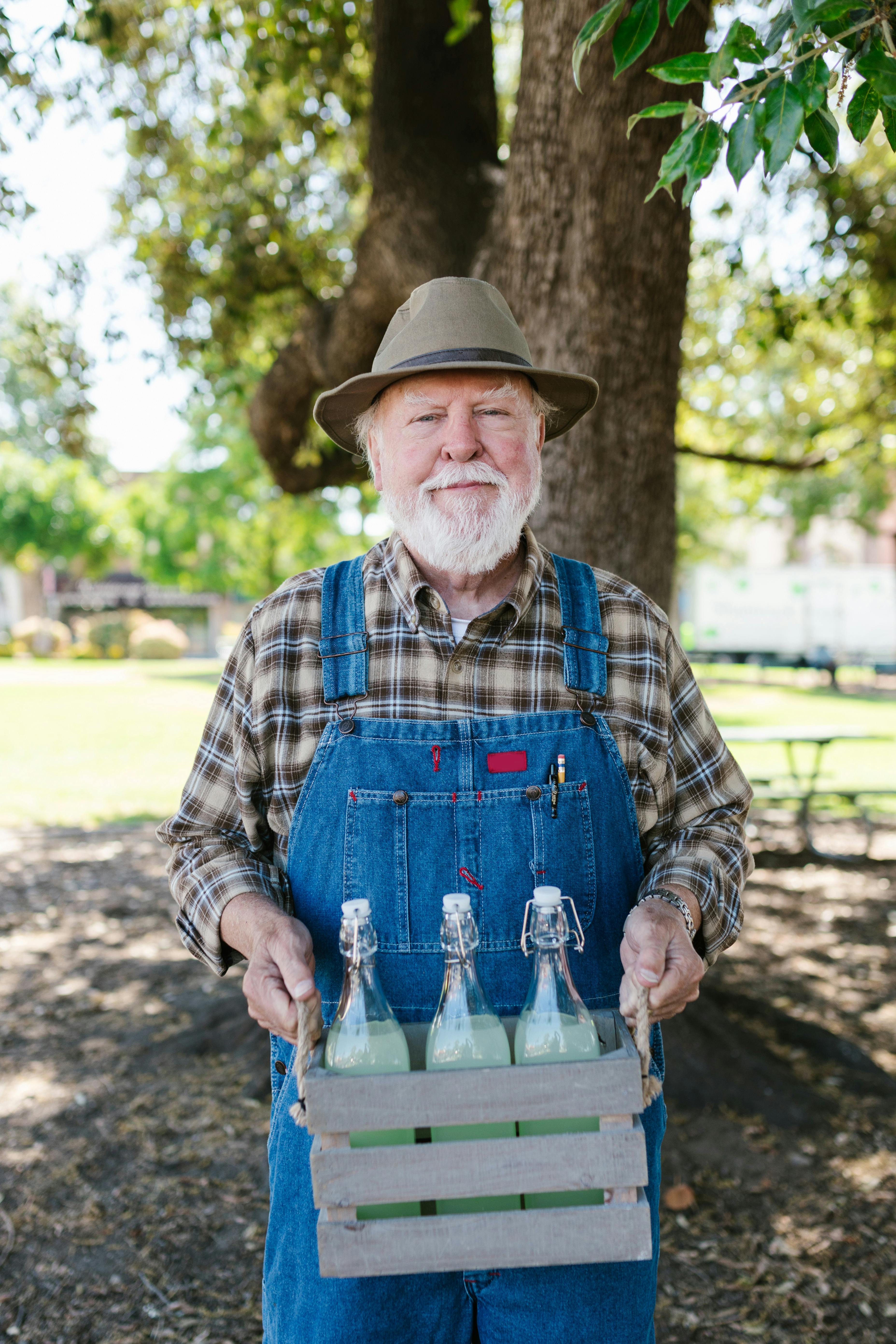 Un agricultor sujetando una caja de botellas | Fuente: Pexels